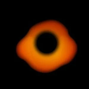 A close-up image of a small orange ring with a black center against a dark background.