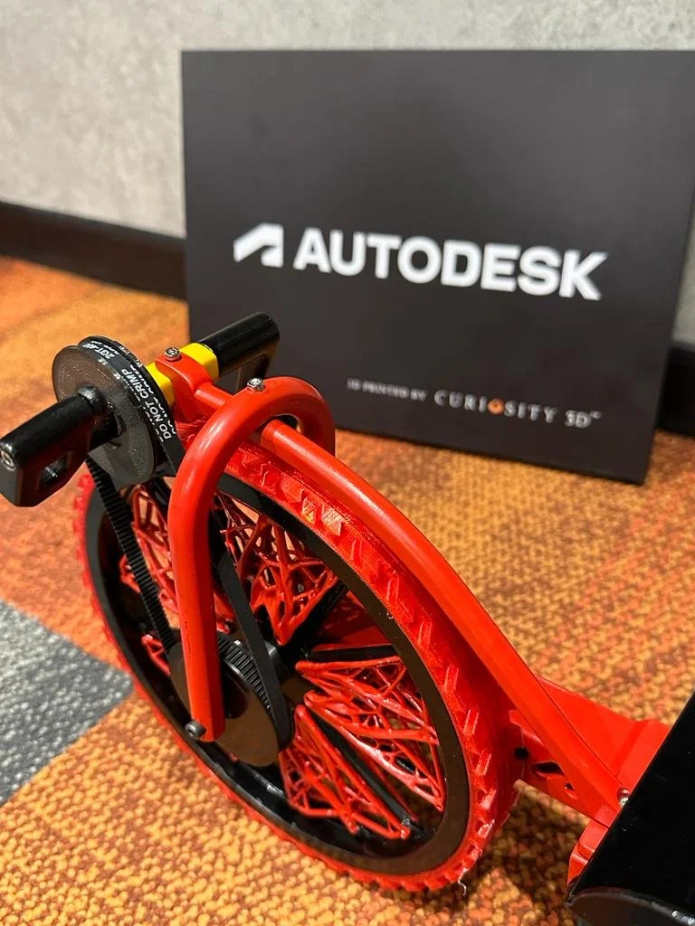 3D-printed red wheel displayed with Autodesk sign