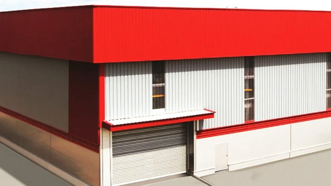 Industrial building with red roof and roller door