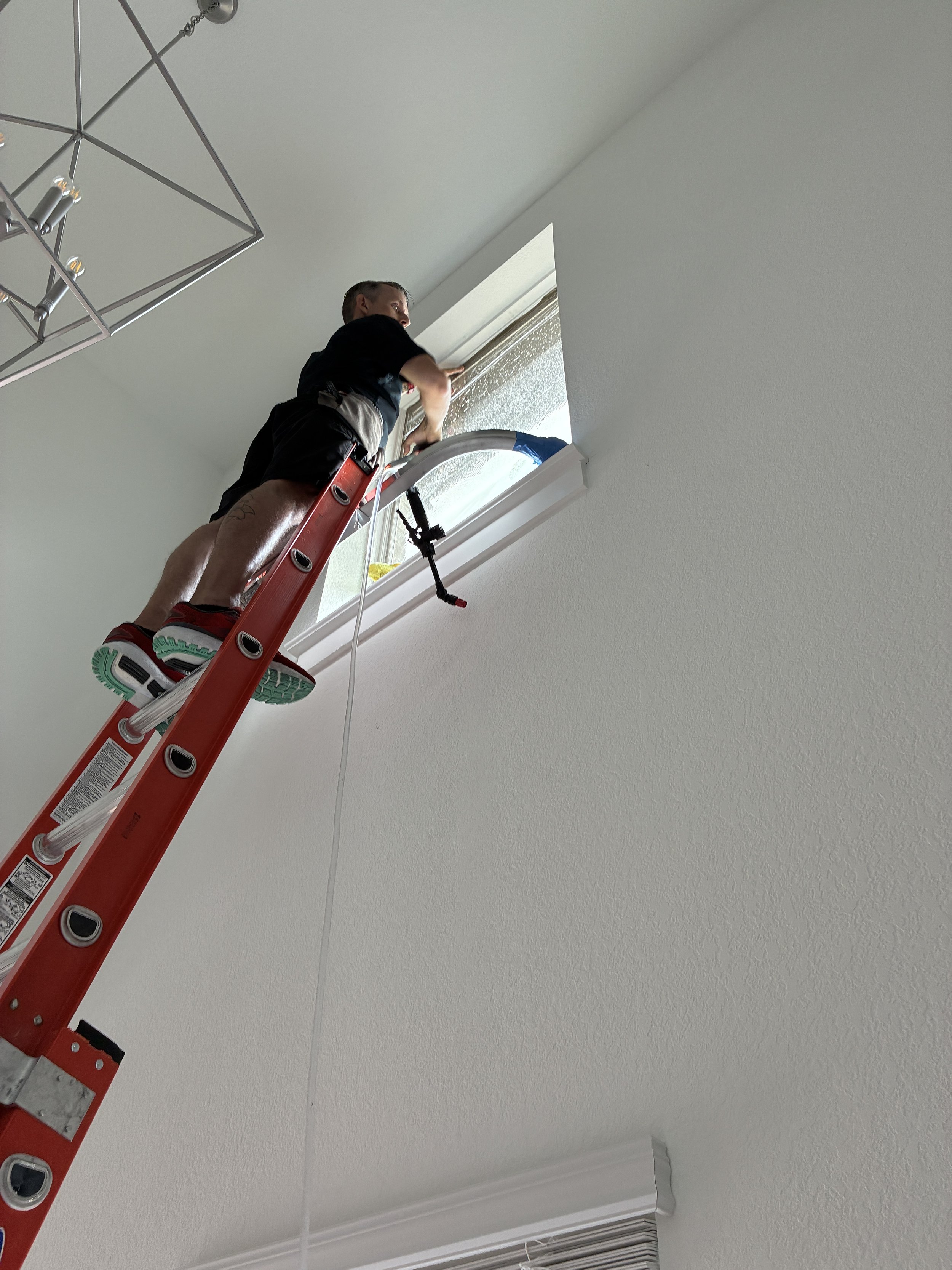 Turbo Tint technician installing window film on a vaulted ceiling window