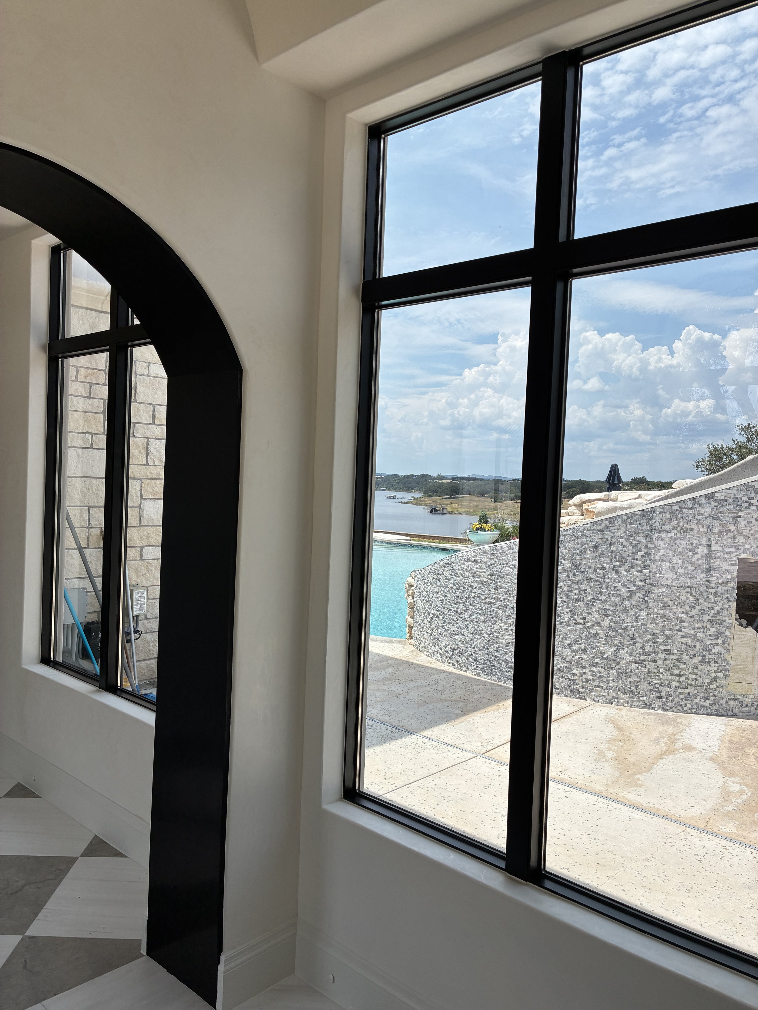 Large windows with solar film installed, framing the lake view