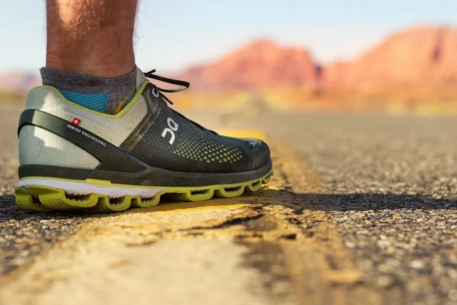 Running shoe on open road with red rock desert background