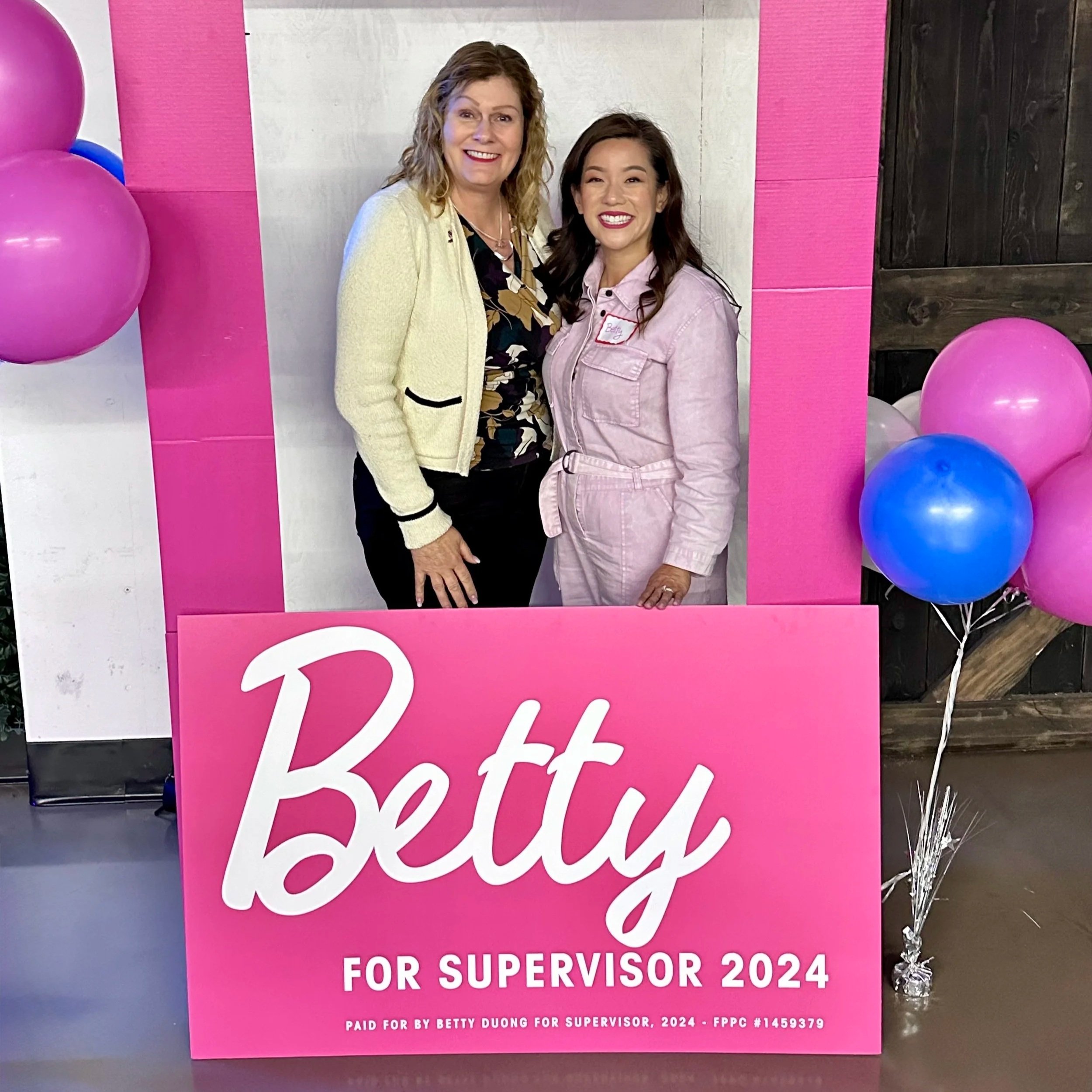Pink sign with white cursive text reading 'Teacher' and smaller text below indicating it is for supervisor 2024, with balloons around the sign.