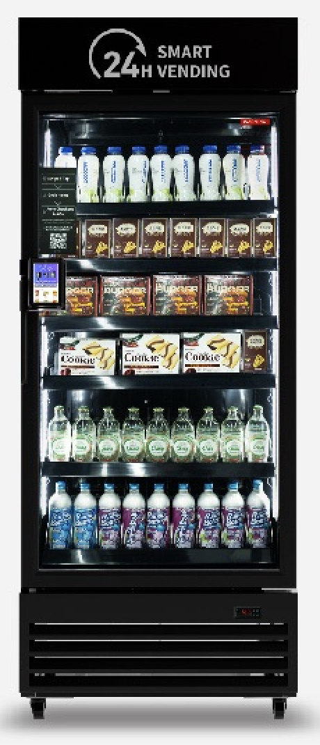 A vending machine stocked with various bottled drinks, snacks, and confectioneries, with a digital payment panel on the left side and a sign at the top reading '24 Hour Smart Vending'.