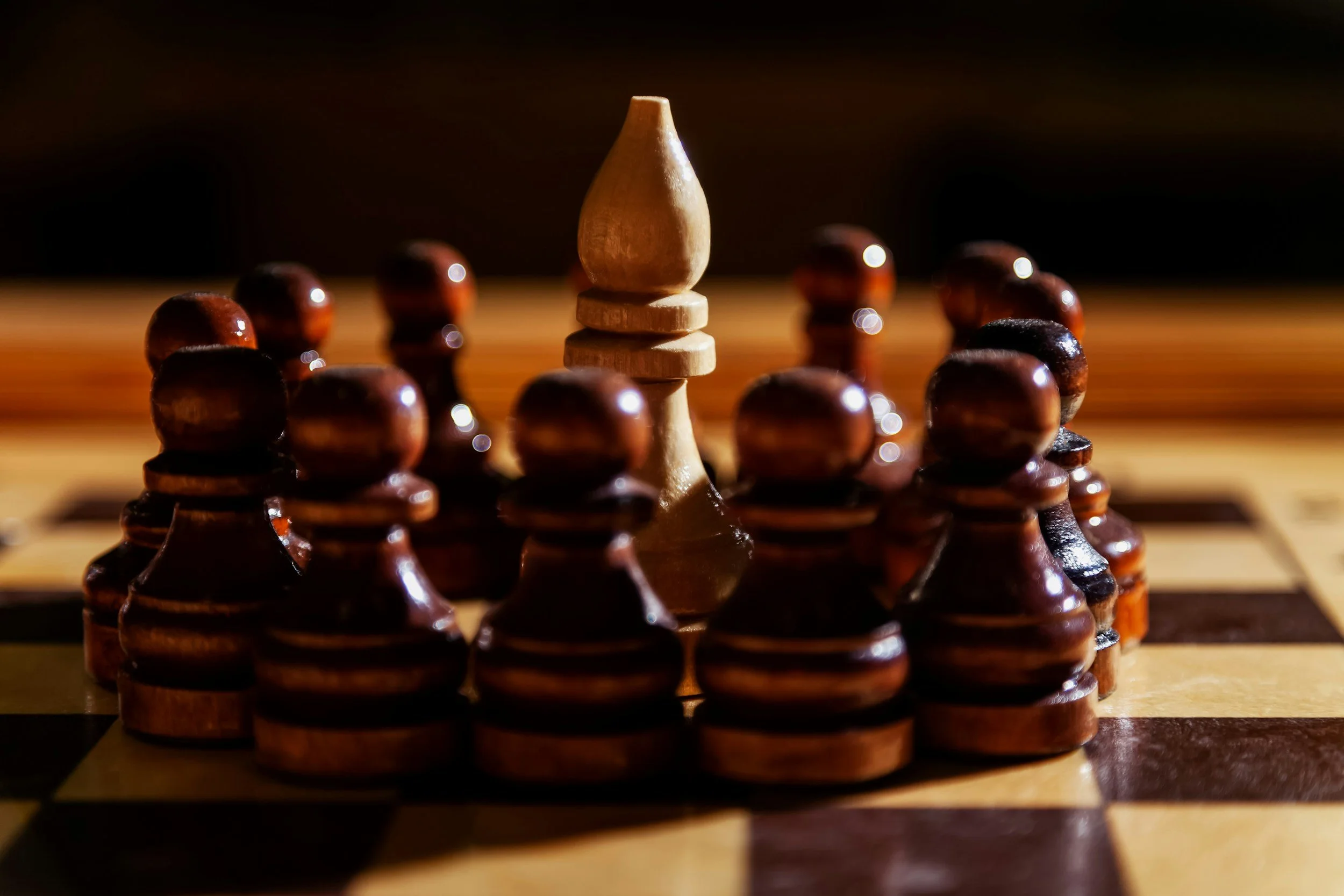 A chessboard with a close-up of a pawn surrounded by other pawns in the background, with warm lighting creating a dramatic effect.
