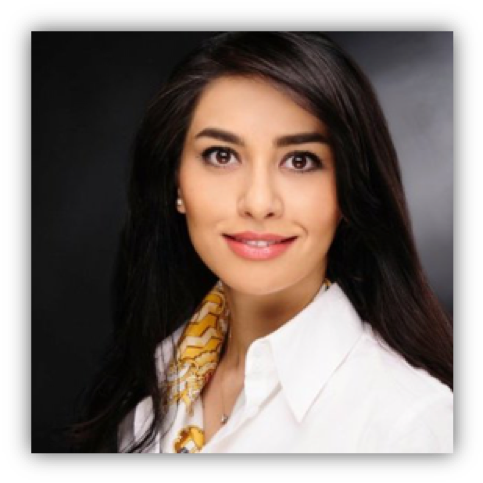 Portrait of a smiling woman with long dark hair, wearing a white shirt and a yellow scarf, against a dark background.