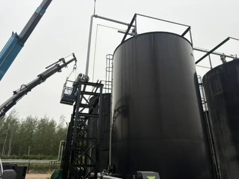 Industrial storage tanks and a crane in an outdoor facility.