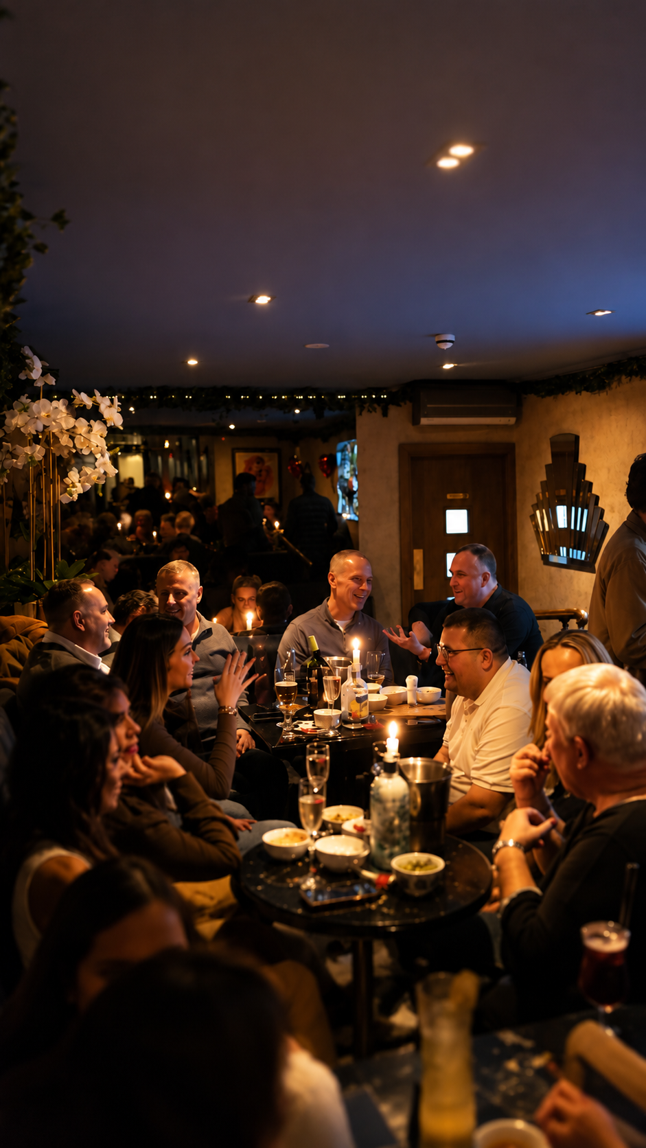 People gathered around tables at Ninety Seven Bar & Lounge, socializing and enjoying food and drinks in a warmly lit atmospheric setting. 97 bar Sidcup, Kent.