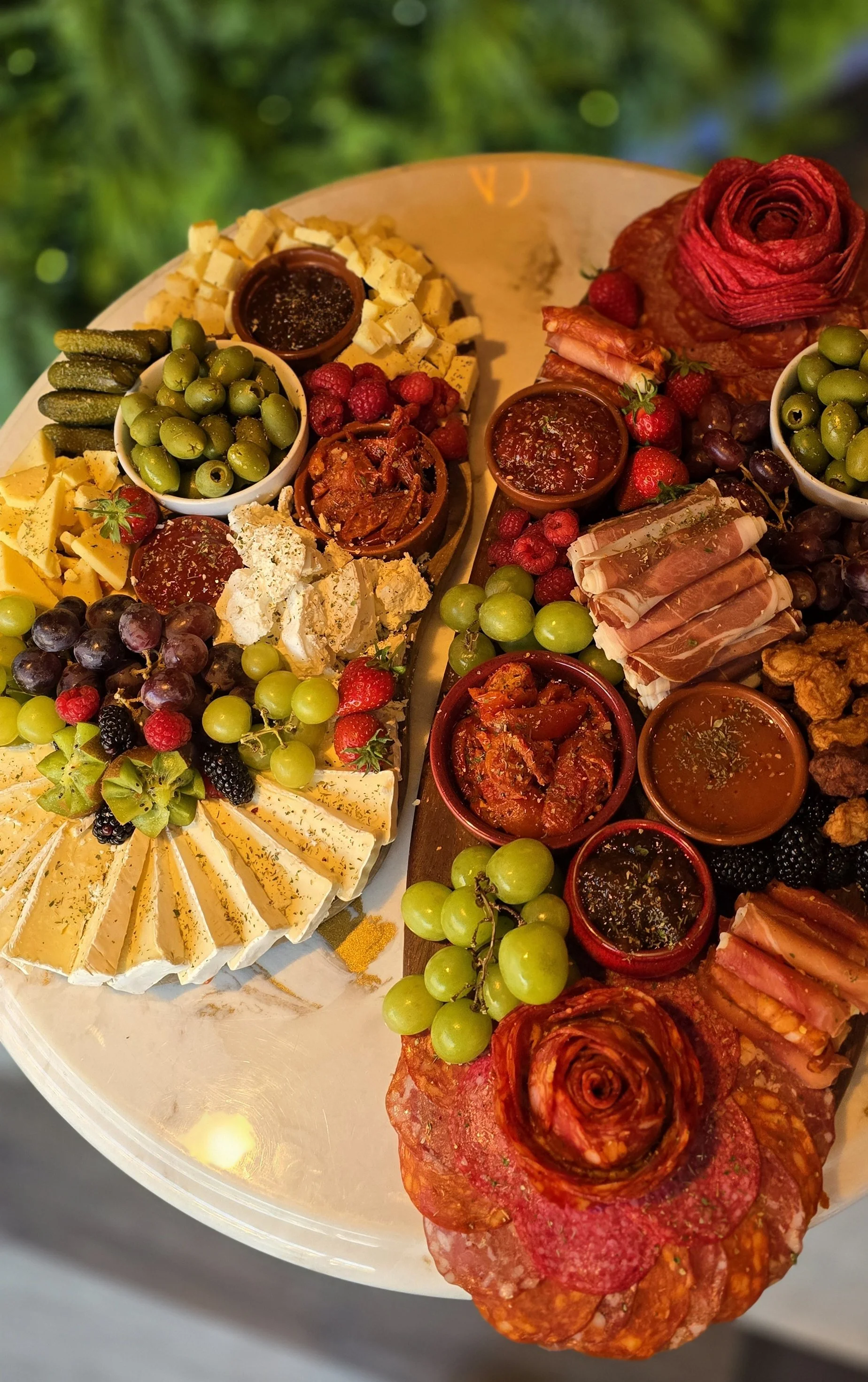 A platter featuring an assortment of cheeses, fruits, charcuterie, and small bowls of dips and sauces, with grapes, strawberries, and raspberries. A premium offering at Ninety Seven Bar & Lounge Sidcup Kent.