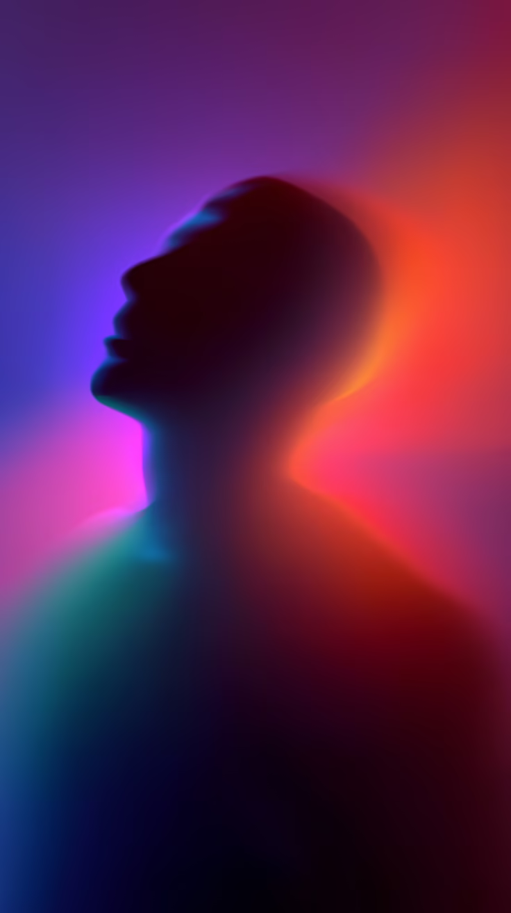 Silueta de una persona con iluminación de colores vibrantes, fondo difuso de tonos morados, rosas y azules.