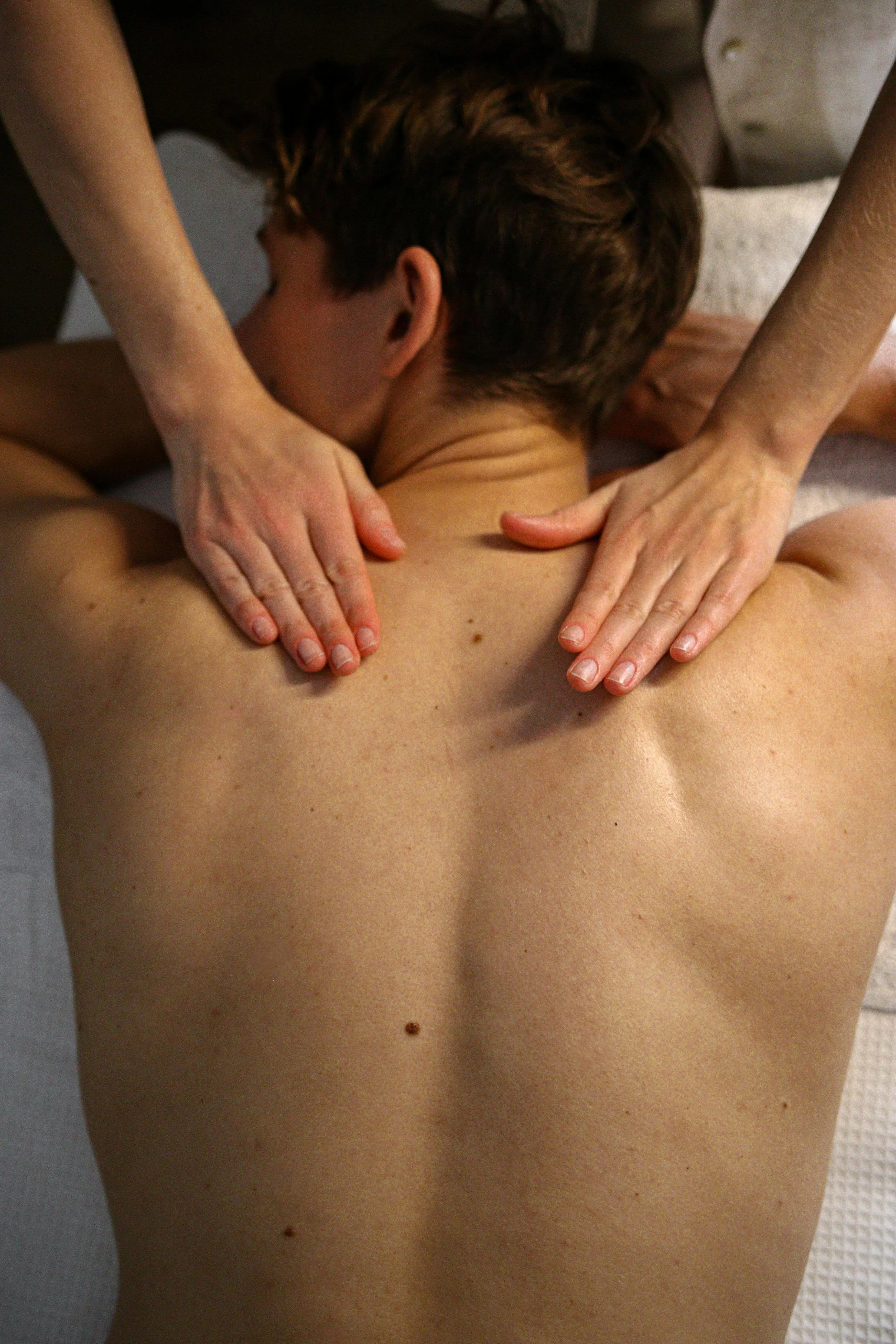 A person receiving a massage on their back in a spa or wellness setting.