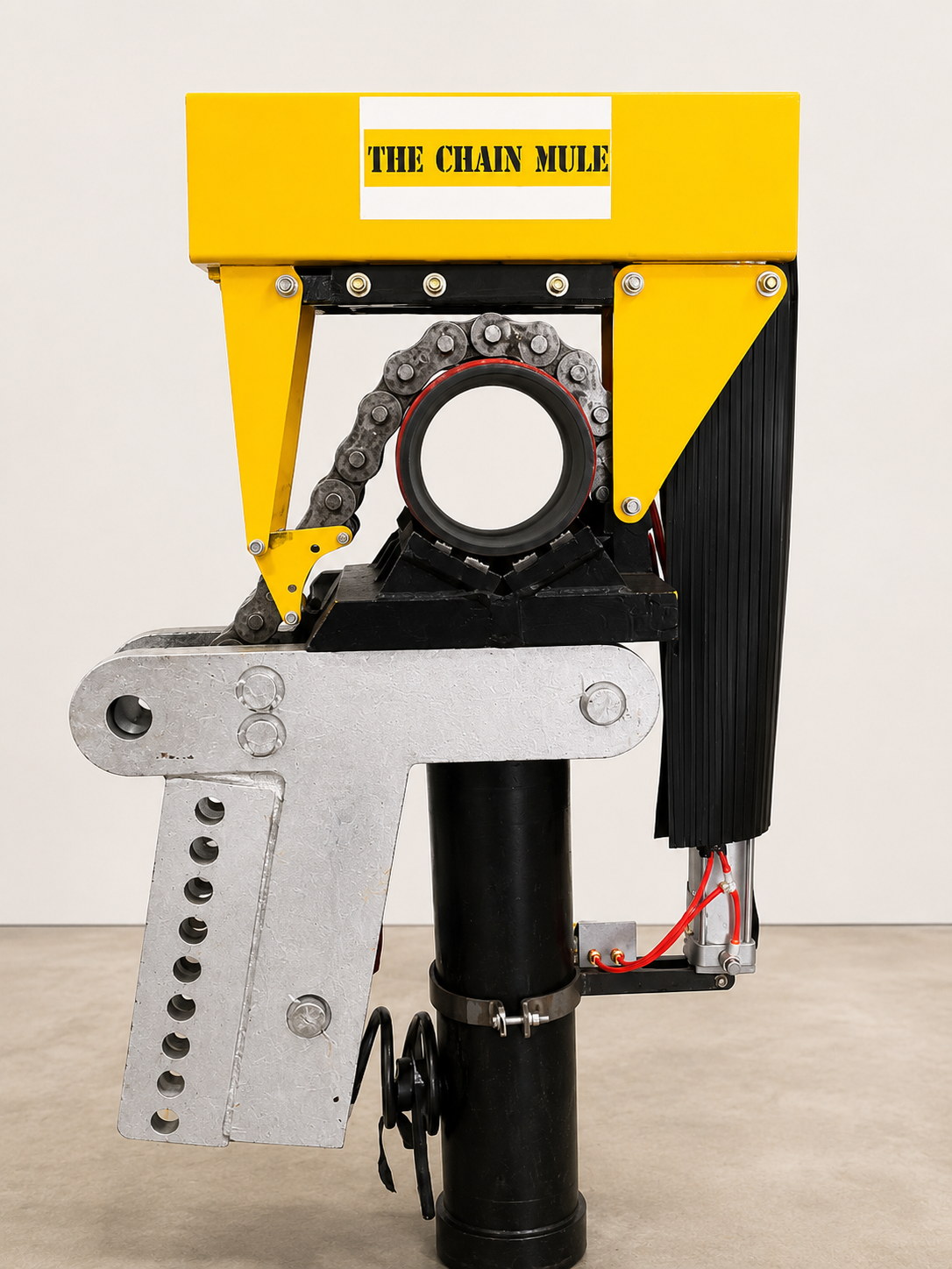 A mechanical robot with a yellow top labeled 'The Chain Mule', featuring a large gear, a gear chain, and various metal and black components, standing on a black cylindrical base.