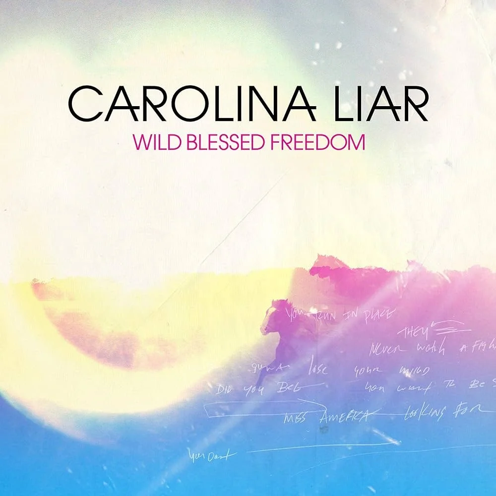 Cover art for an album titled 'Wild Blessed Freedom' by Carolina Liar, featuring abstract pastel colors with a silhouette of a horse and handwritten notes.
