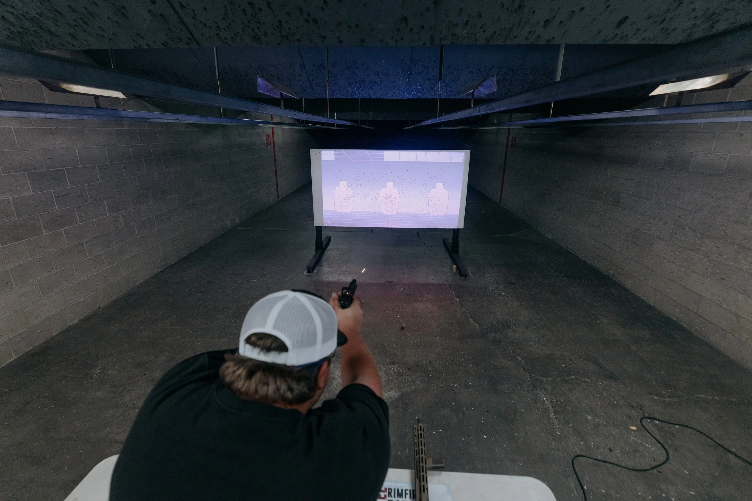 A person takes aim at the Accushoot target screen at Tactical Penguin.