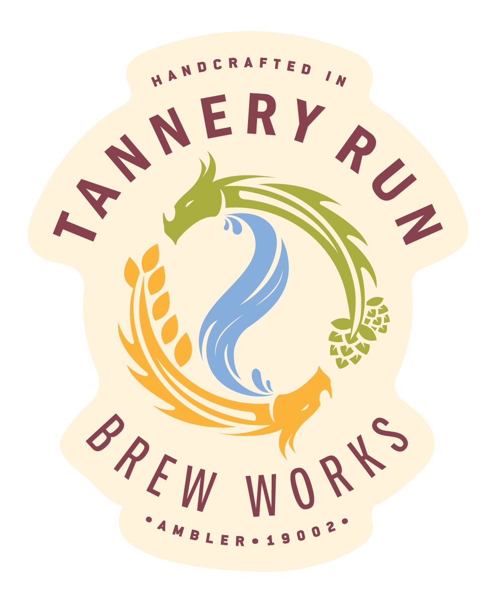 Logo for Tannery Run Brew Works featuring a stylized dragon in green, blue, and orange intertwined with barley and hop illustrations, with text indicating it's handcrafted in Amblar since 19002.