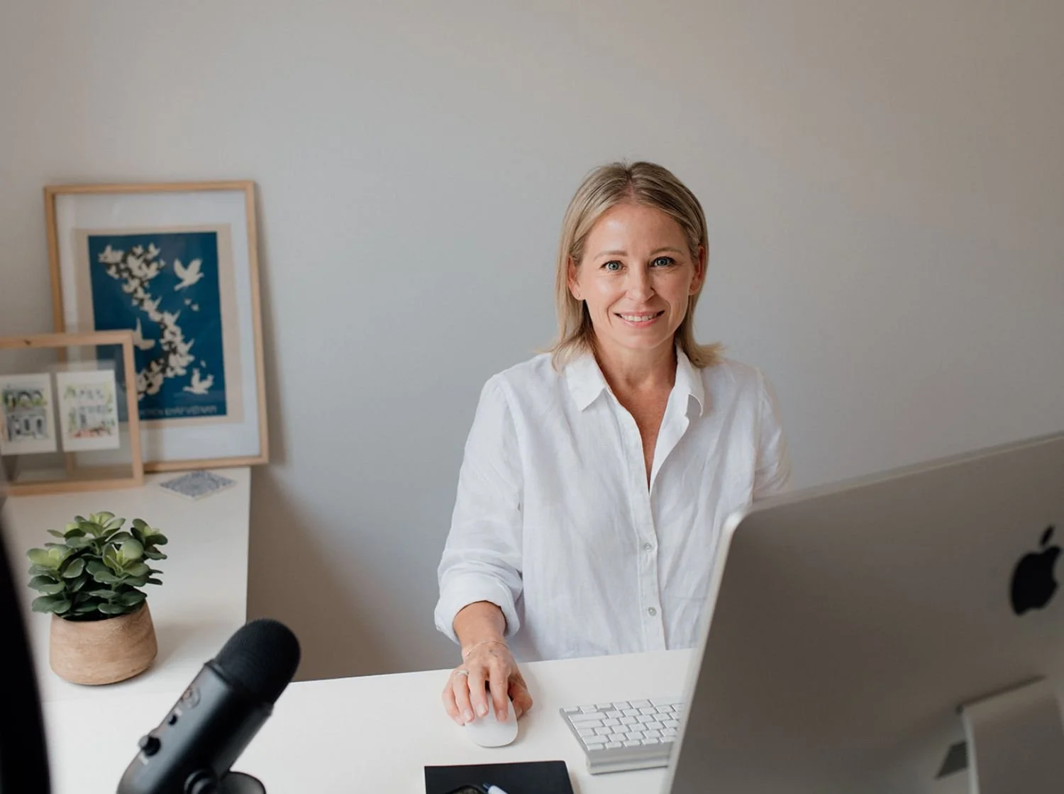 Kim Skilton - founder of Maison Mortgages sitting at her desk with sun filtering in.
