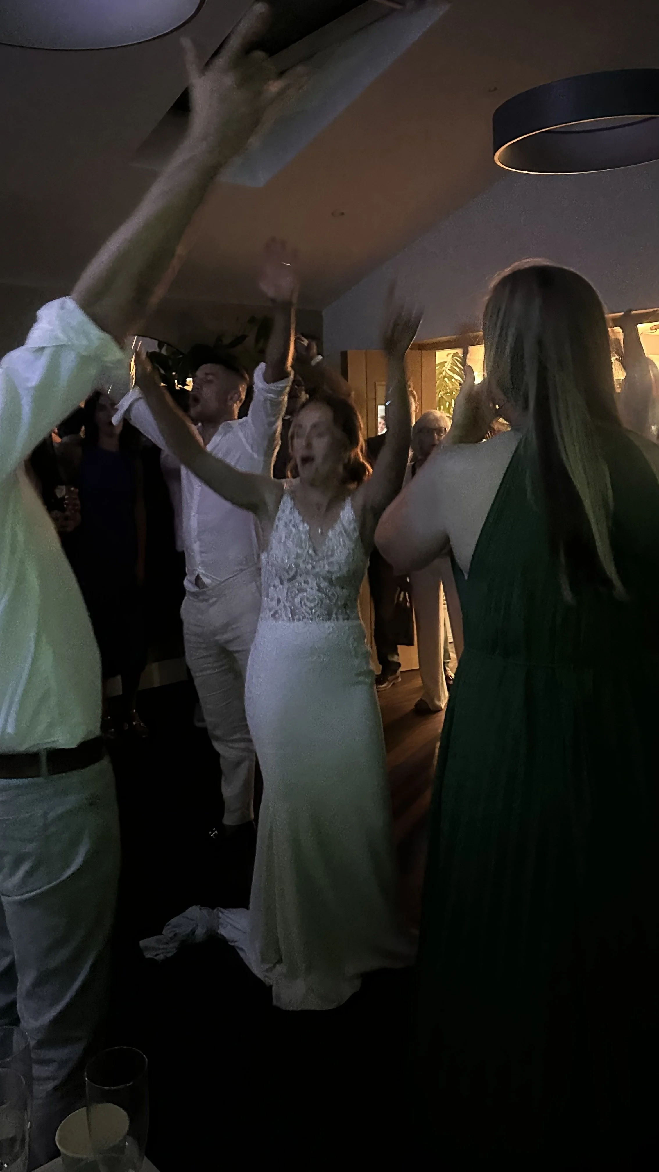 Bride and groom singing and dancing with guests on the dance floor