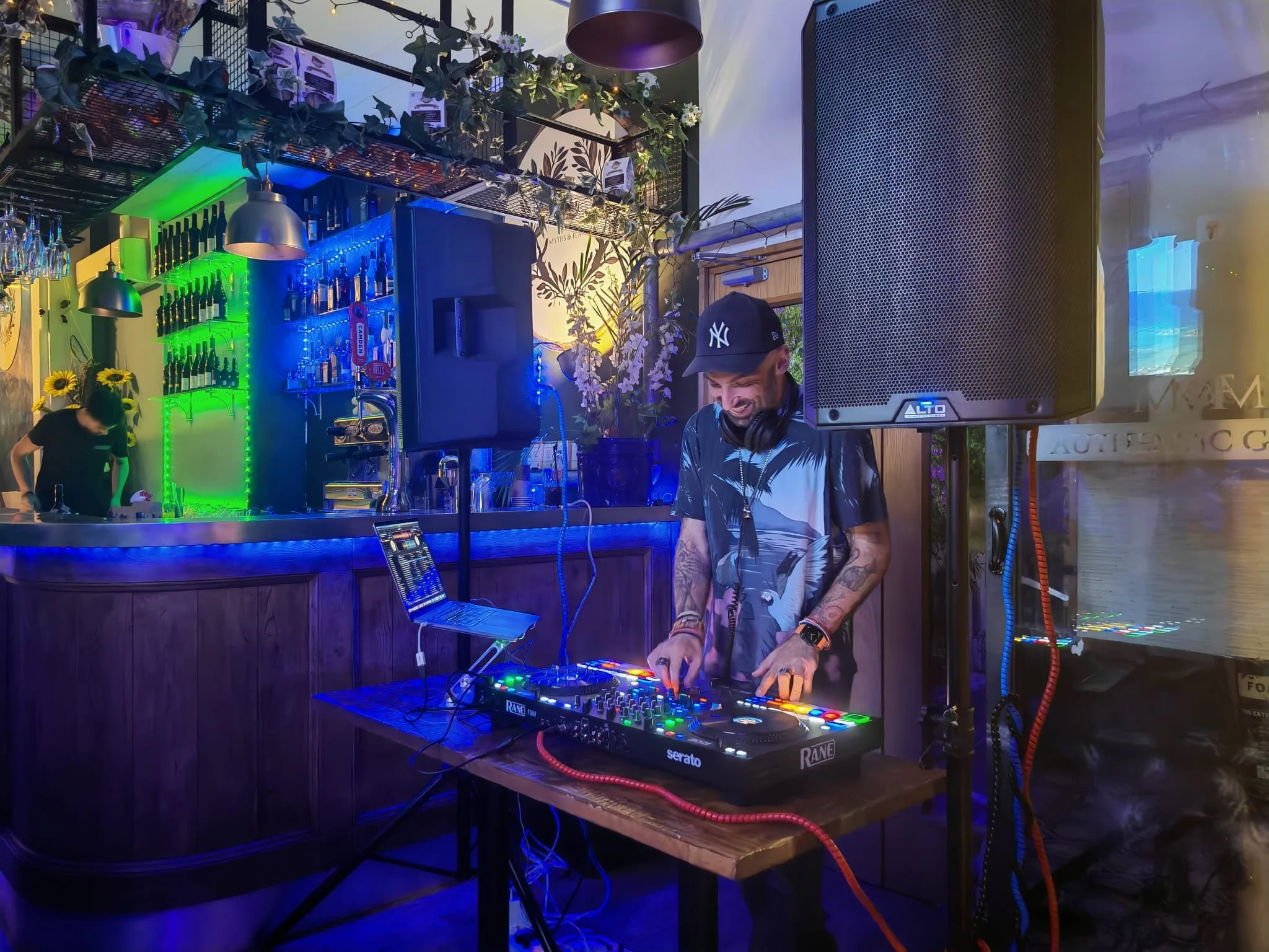 Lucky Evi, London DJ, mixing at a live event at night under blue stage lighting
