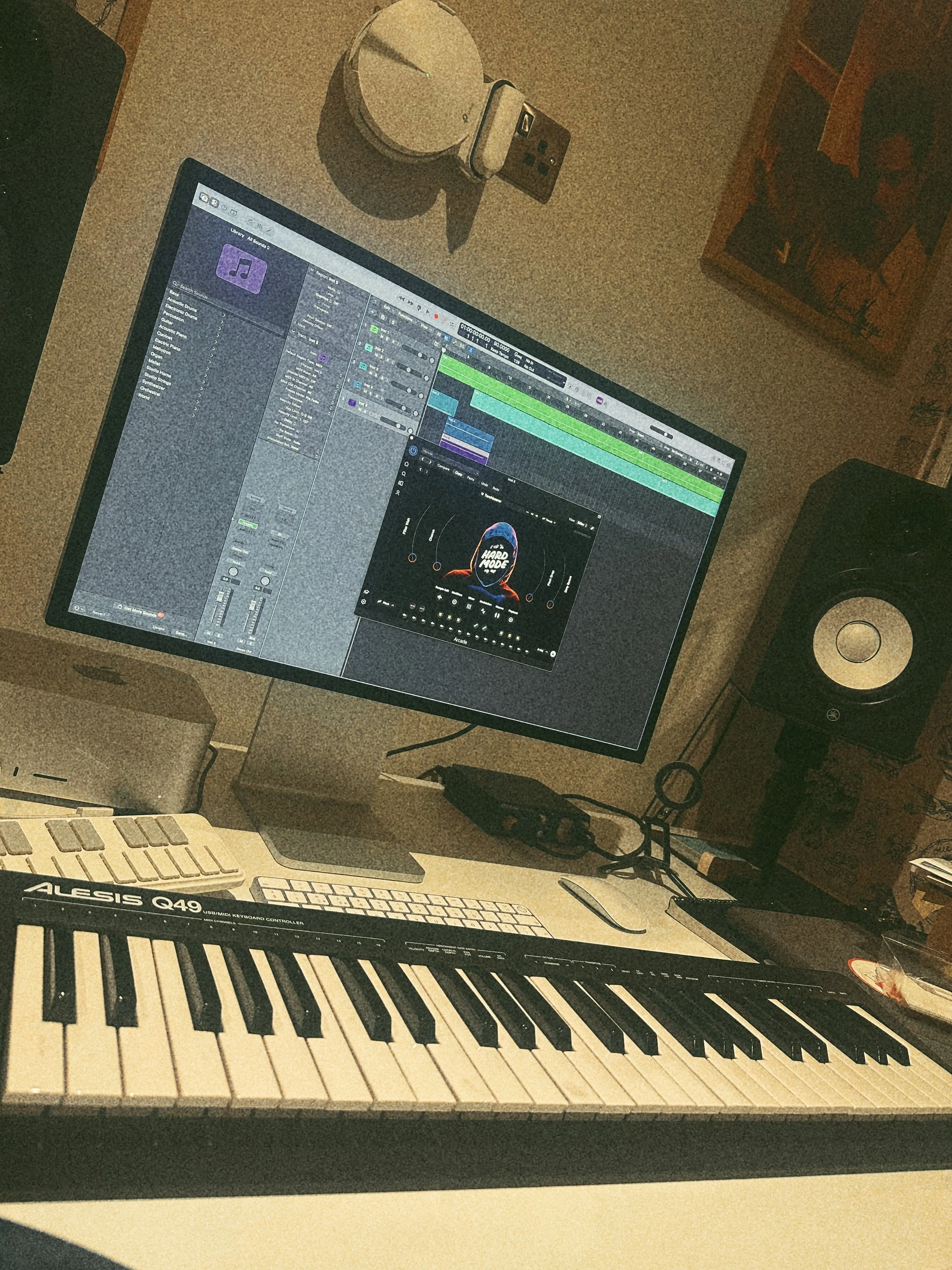 Home studio setup with an Alesis MIDI keyboard and music production software open on screen, used by Lucky Evi