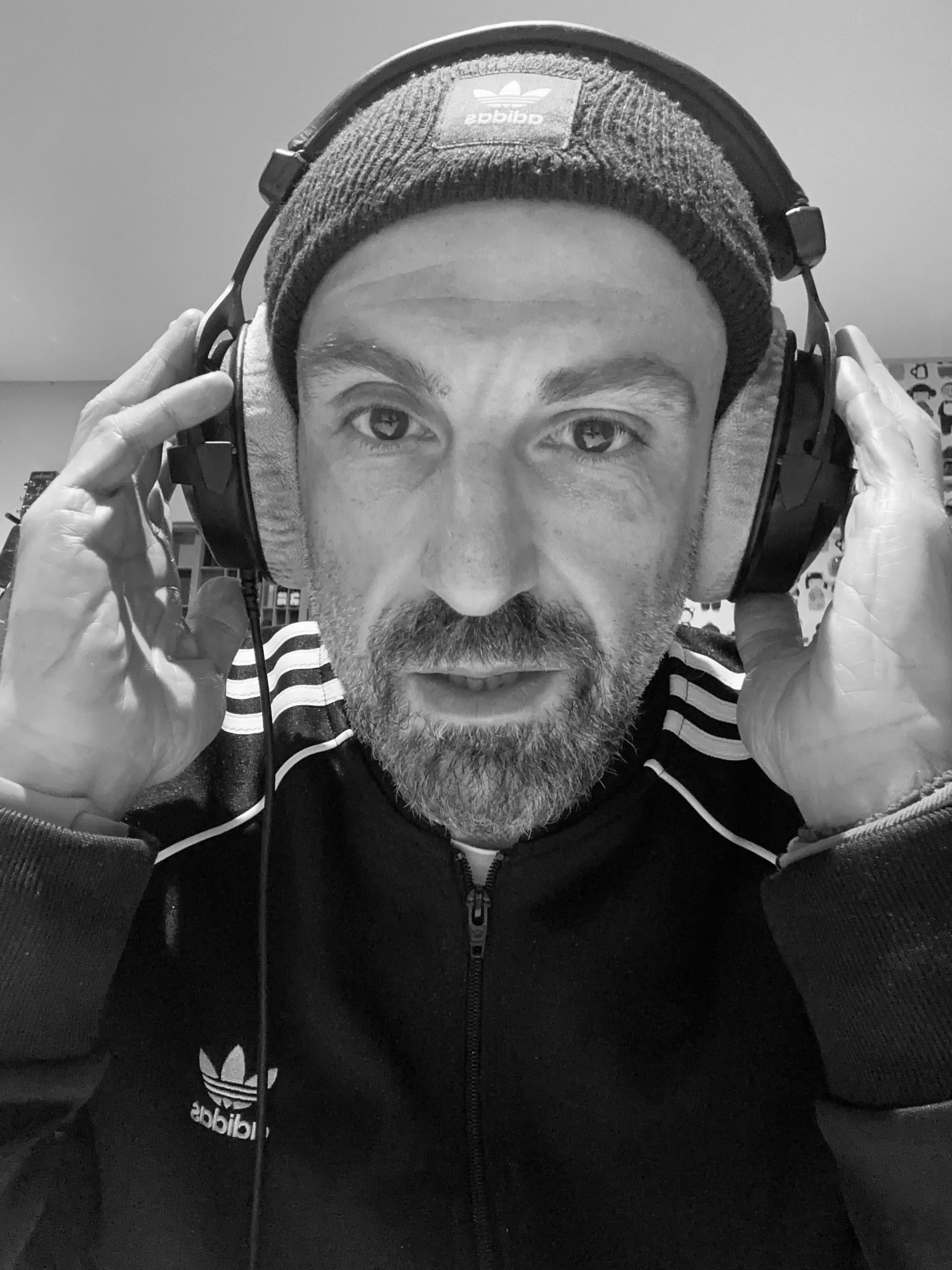Black and white portrait of Lucky Evi adjusting his headphones in the studio