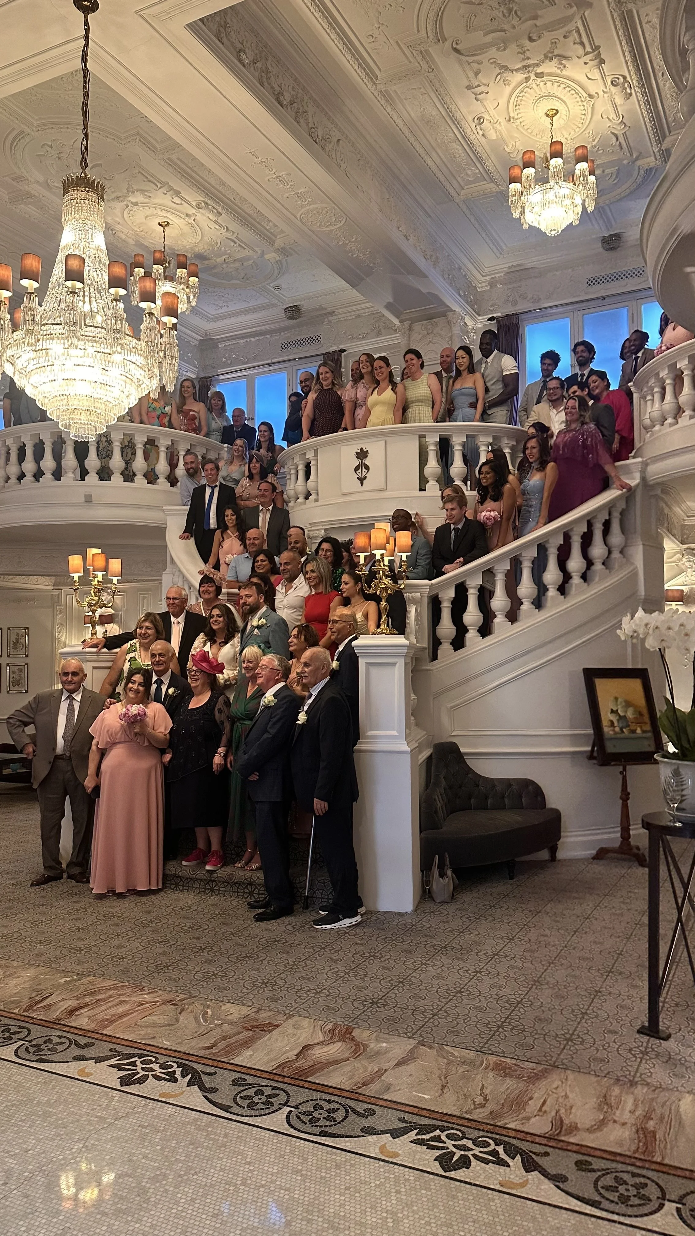 Wedding guests gathered on a grand staircase at a London wedding