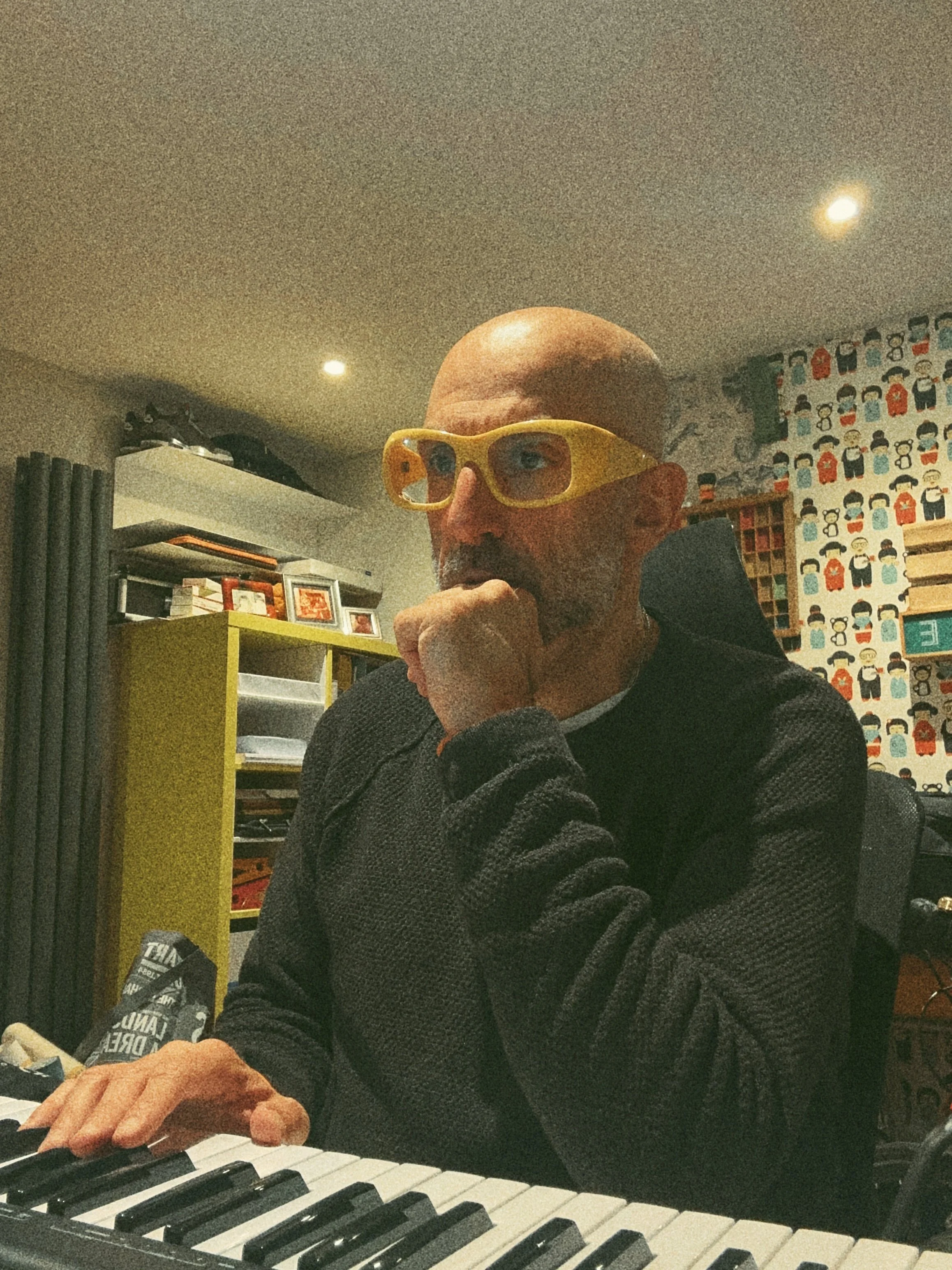 Lucky Evi making original music at a keyboard in his home studio.