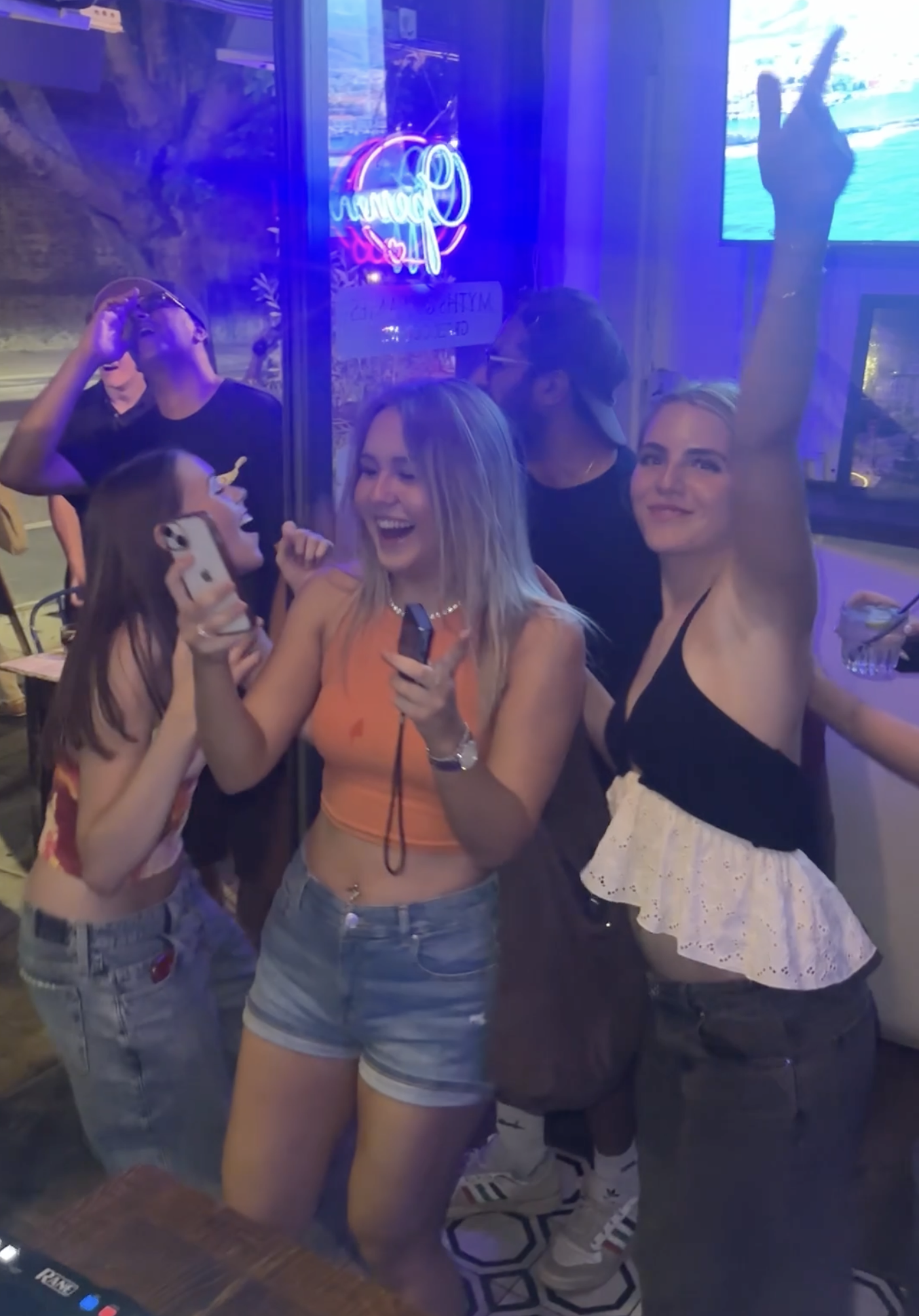 Guests celebrating at a bar event with neon lighting