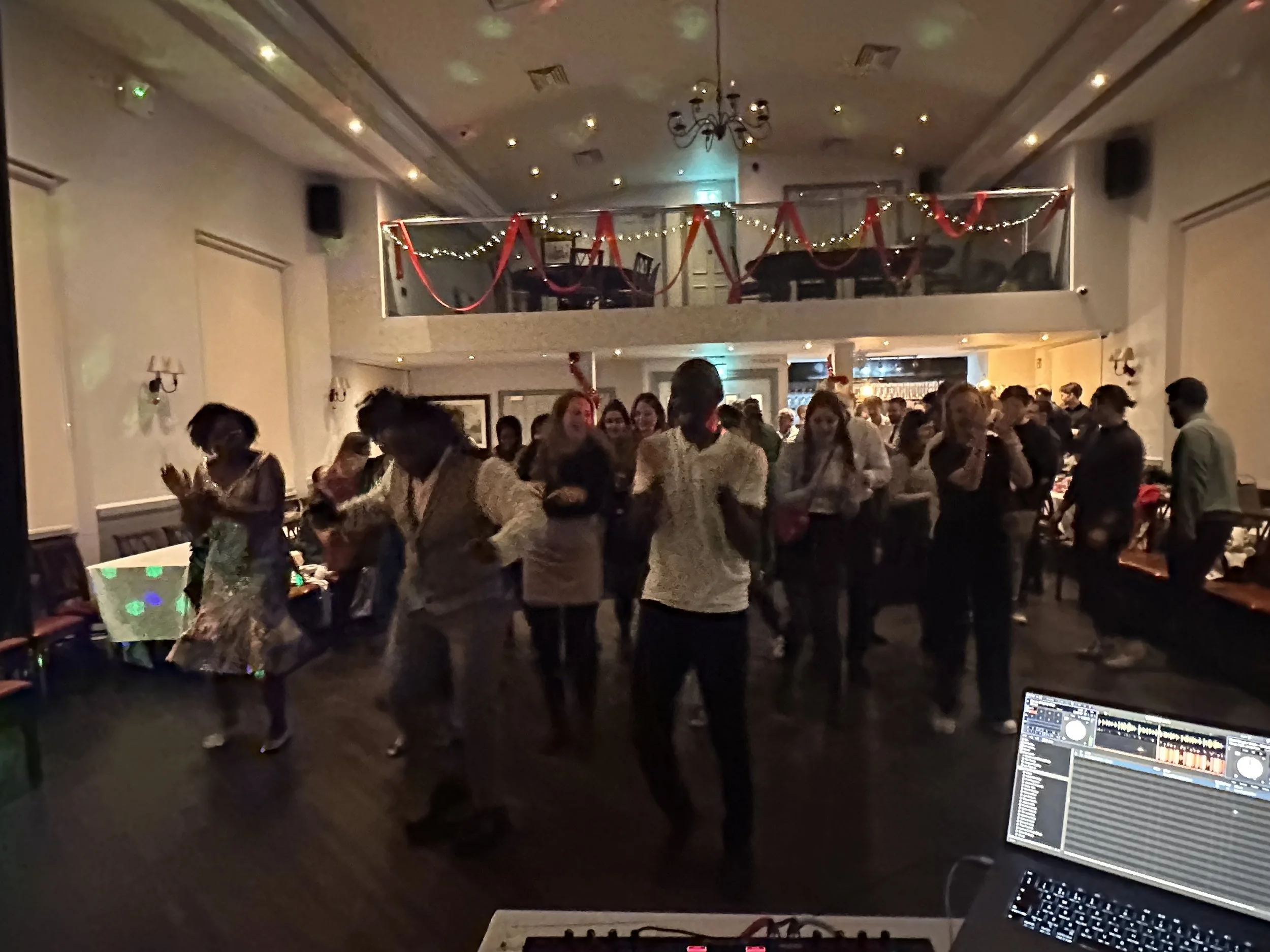 Crowd dancing at a Lucky Evi hip-hop and RnB DJ set, decks in the foreground