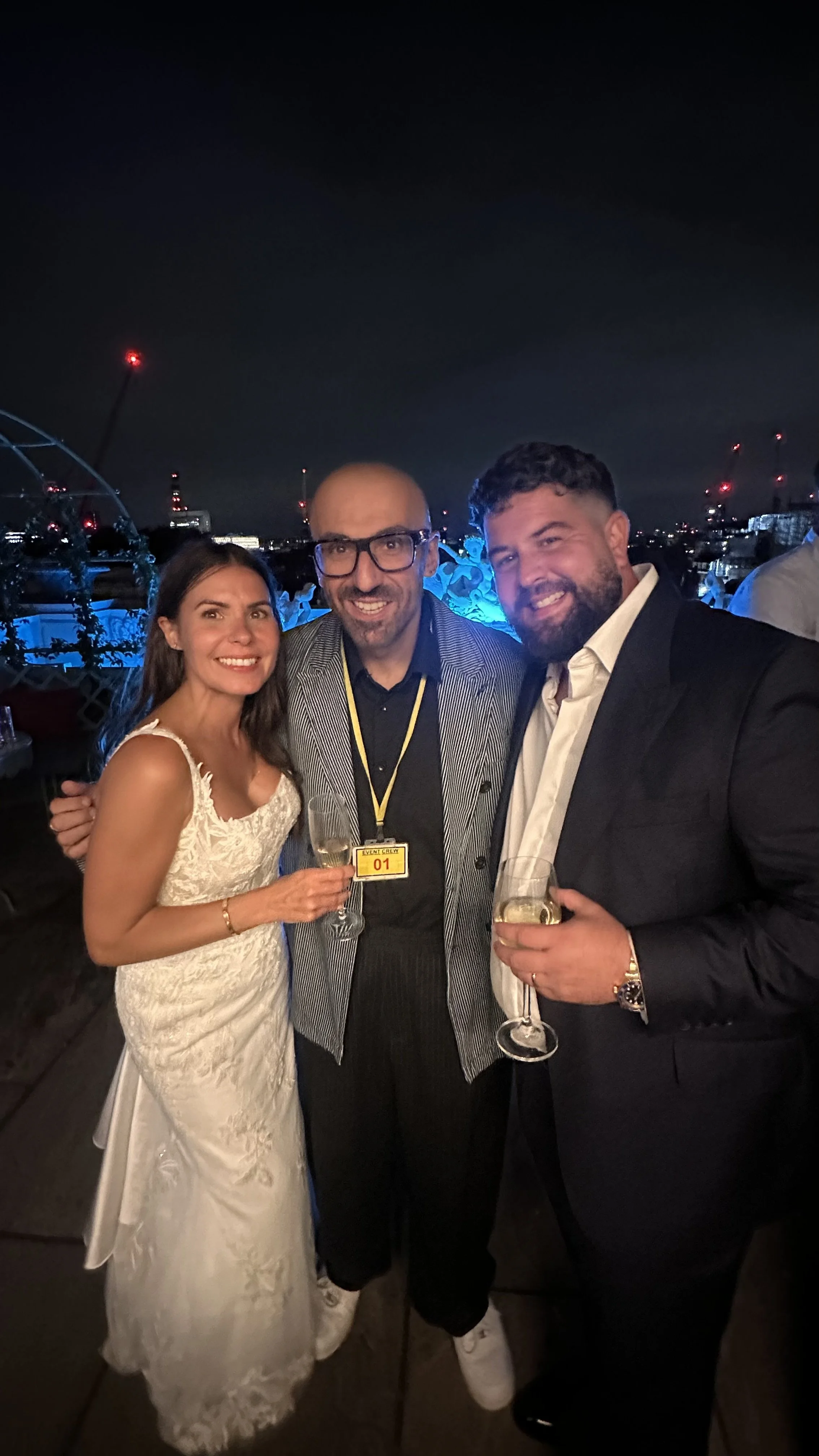 Lucky Evi with wedding guests on a rooftop overlooking the London skyline