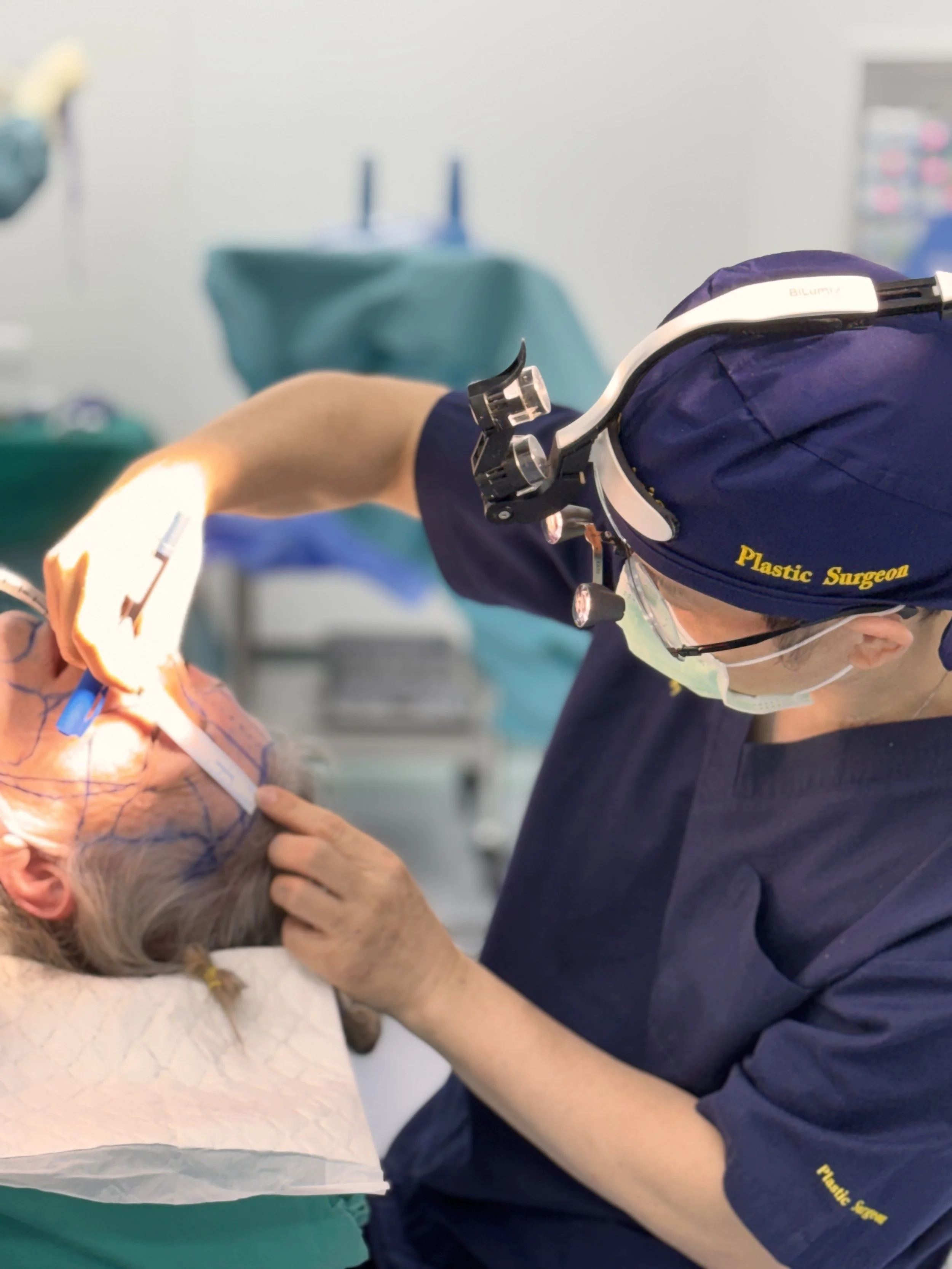 A surgeon performing heart surgery on an elderly patient, wearing surgical scrubs, gloves, and a headlamp, in an operating room.