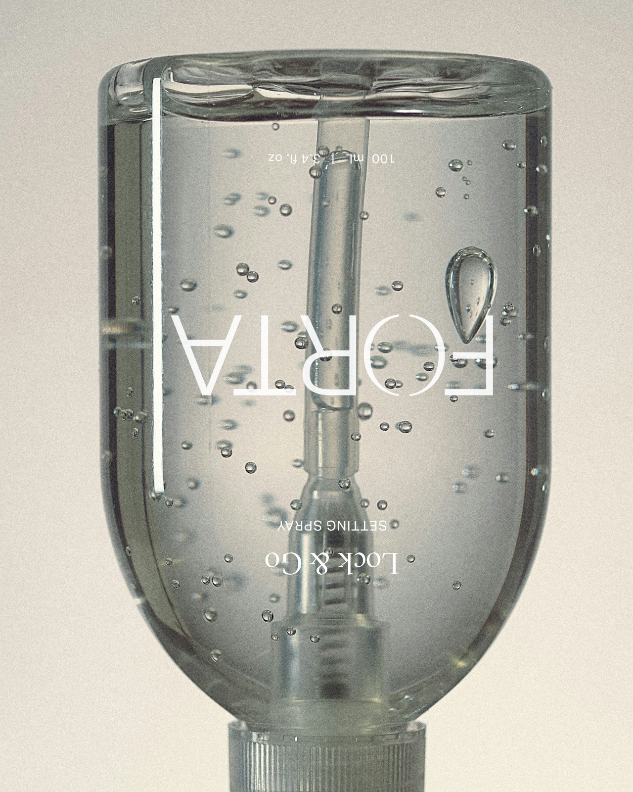 A clear plastic bottle filled with sparkling water and bubbles, with upside-down white text that reads 'FOUR', 'LACK & CO', and 'SETTING SPRAY'.