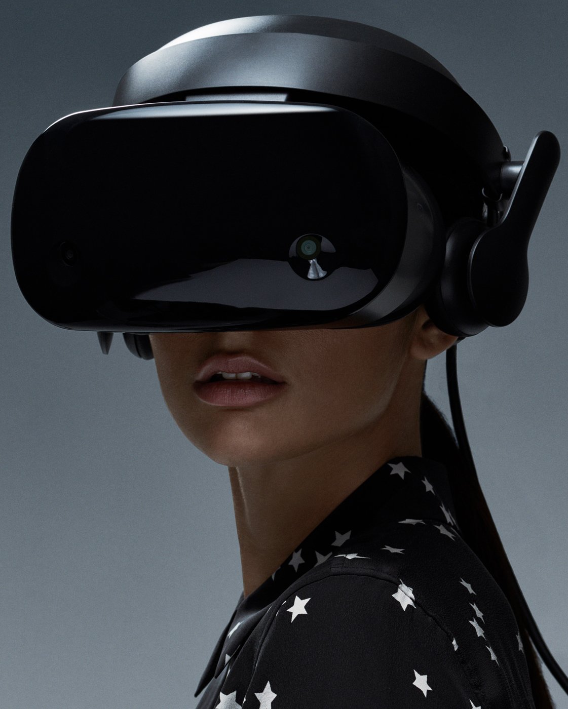 A woman wearing a virtual reality headset with a dark background.