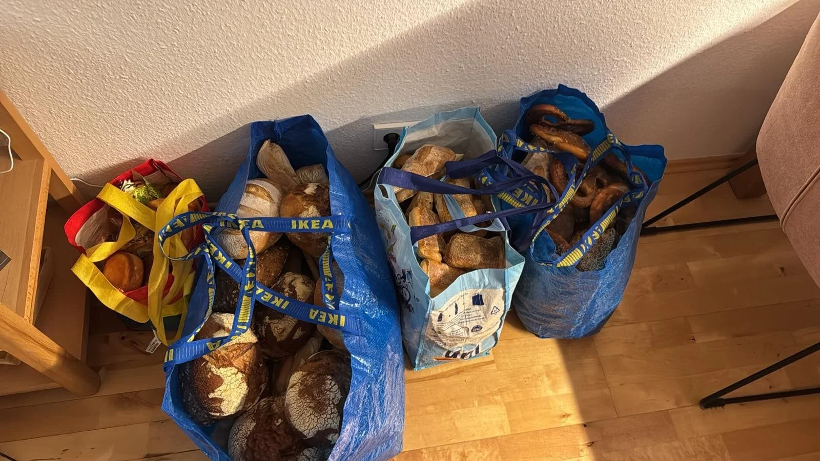 Große, blaue Plastiktüten, die gefüllt sind mit Backwaren aller Art.