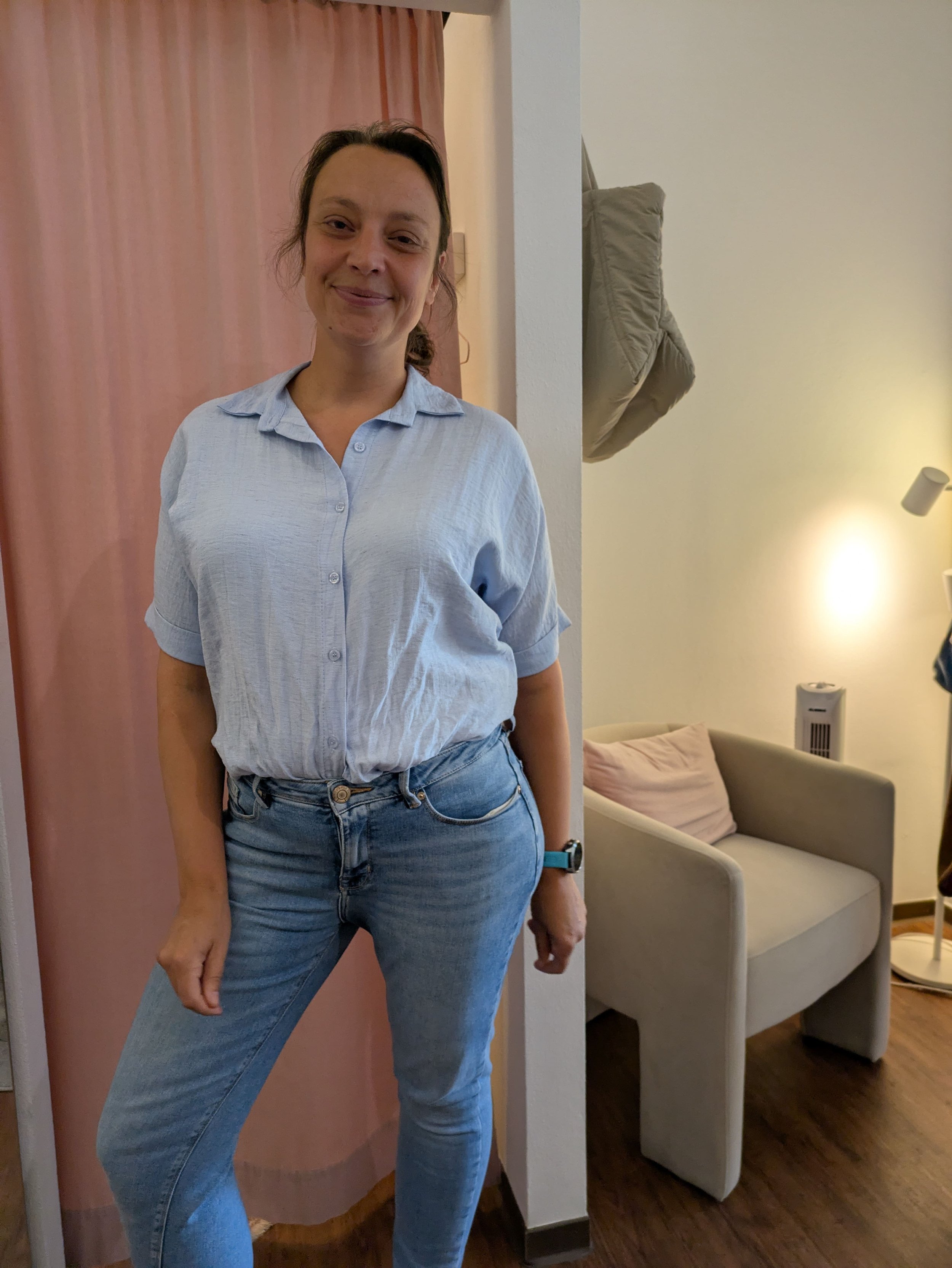 Auf dem Foto ist eine Frau um die 40 zu sehen, sportliche Figur. Die Haare sind zu einem Pferdeschwanz gebunden. Sie trägt eine Jeans und eine hellblaue Leinenbluse.