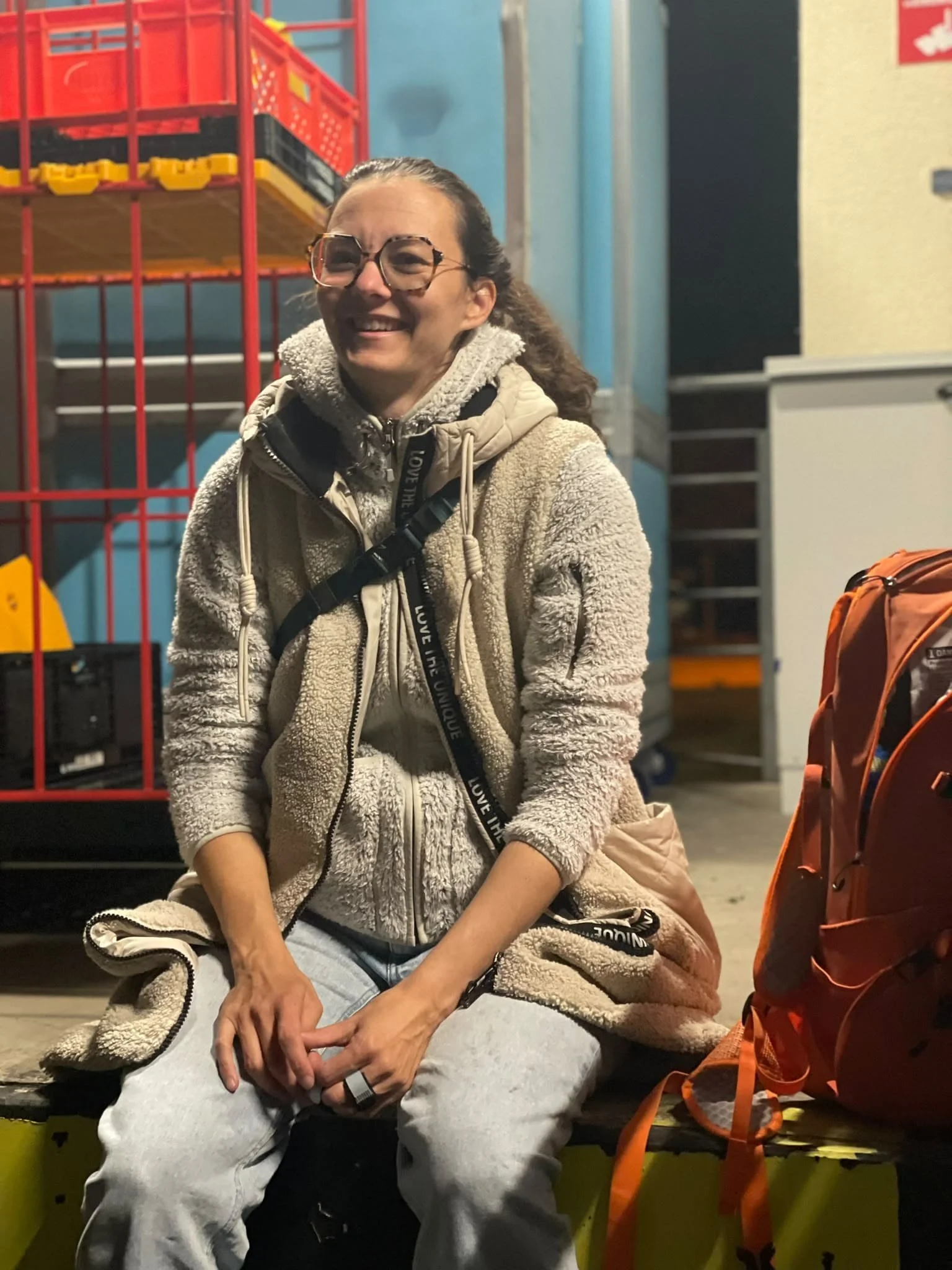 Junge Frau mit Brille und langen, braunen Haaren, die zu einem Pferdeschwanz gebunden sind.