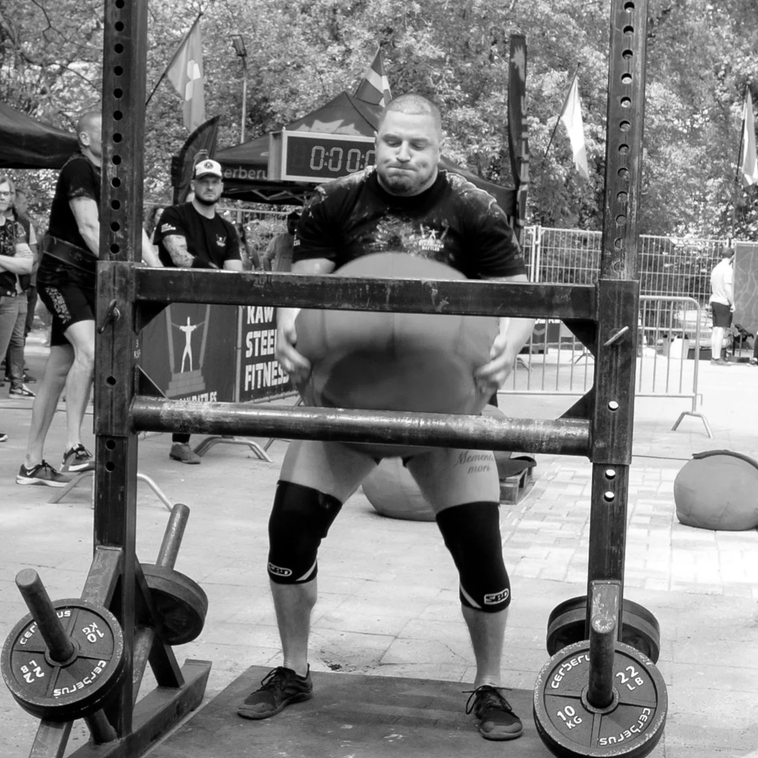 Head coach and founder Martin is competing in a strongman event, performing 90kg sand stone over the bar.