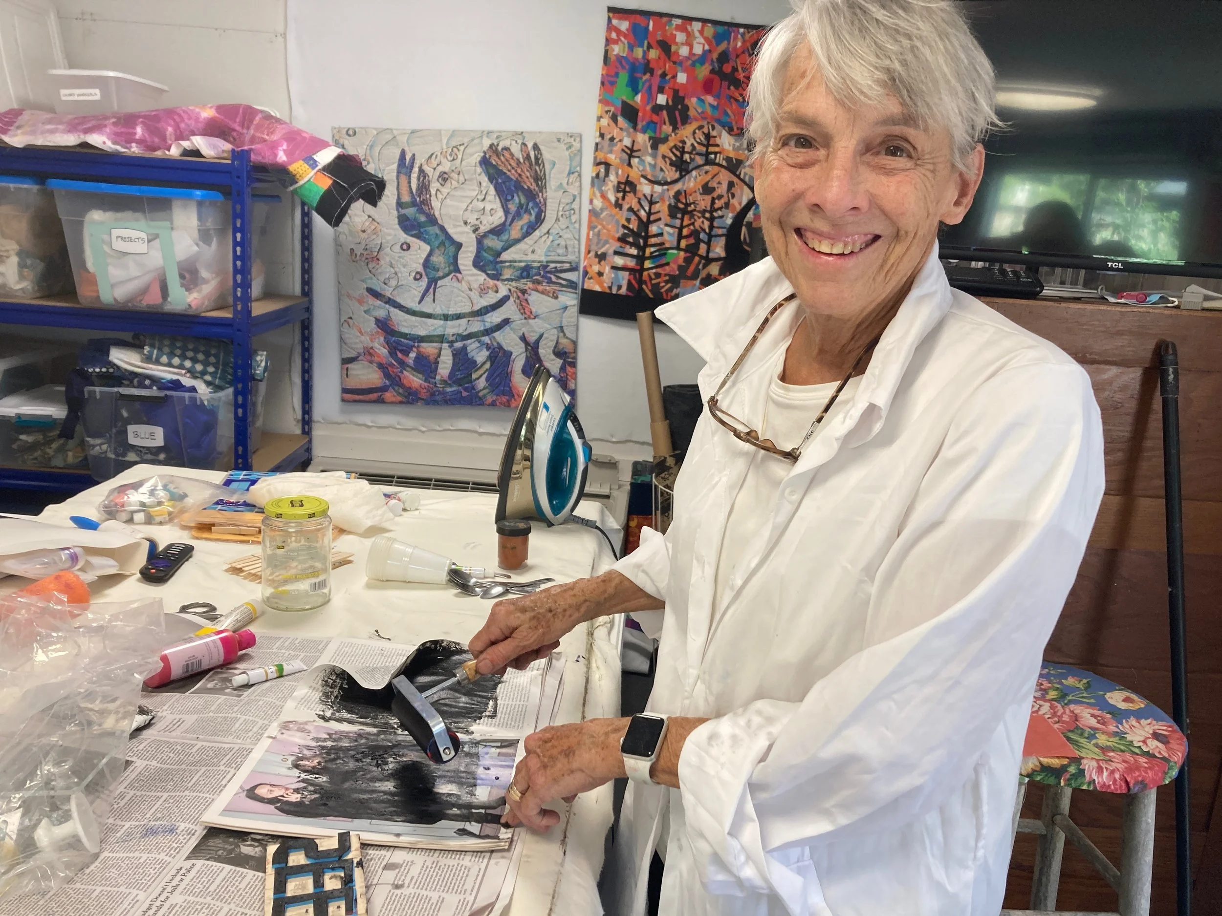 Susie Monday in white shirt with big smile brayerering for a print