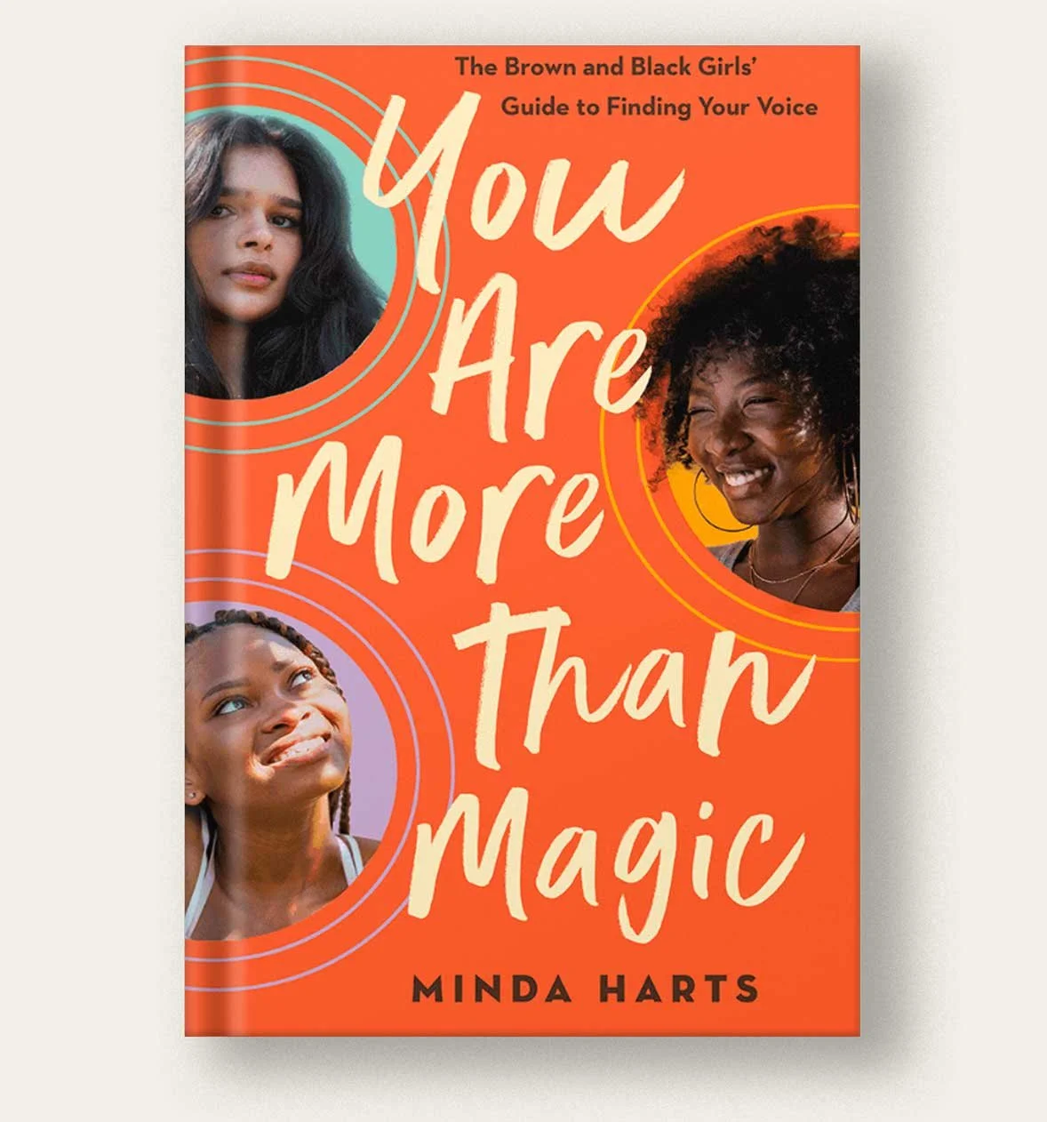 Book cover titled 'You Are More Than Magic' by Minda Harts, featuring photos of three Black women with varying expressions, set against an orange background with circular graphic accents.