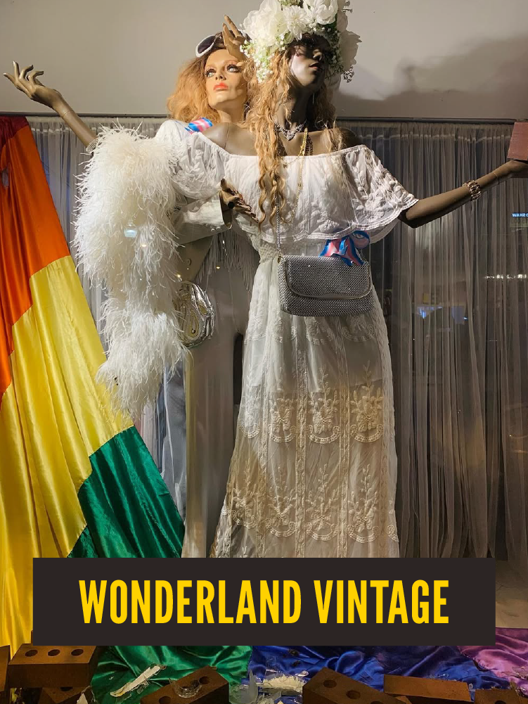 laborate, bohemian and romantic-style clothing, with the scene labeled "Wonderland Vintage."  by a rainbow flag backdrop.  Westport East.