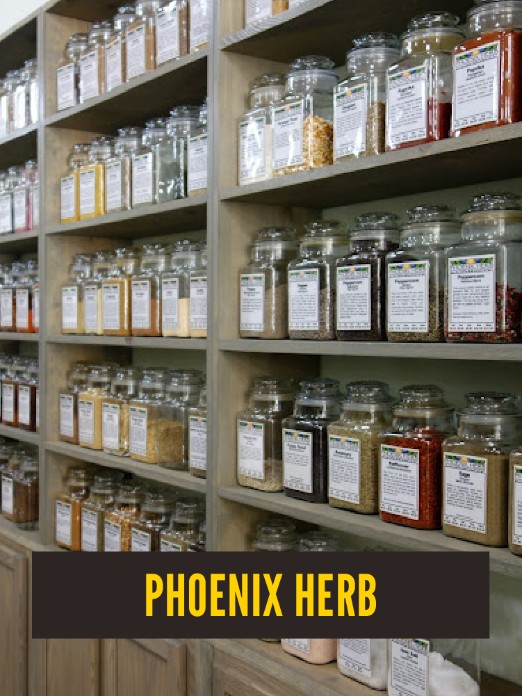 Shelves filled with glass jars containing various dried herbs and spices, each labeled with product information, in a store or herbal shop.  Westport East.