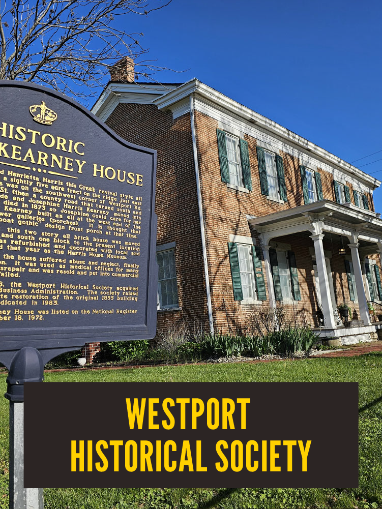 A historic brick house with green shutters and white columns, located at 502 Westport, with a sign in front explaining its history and a large black sign reading 'Westport Historical Society' in front of the house.  Westport East. Kearney House.