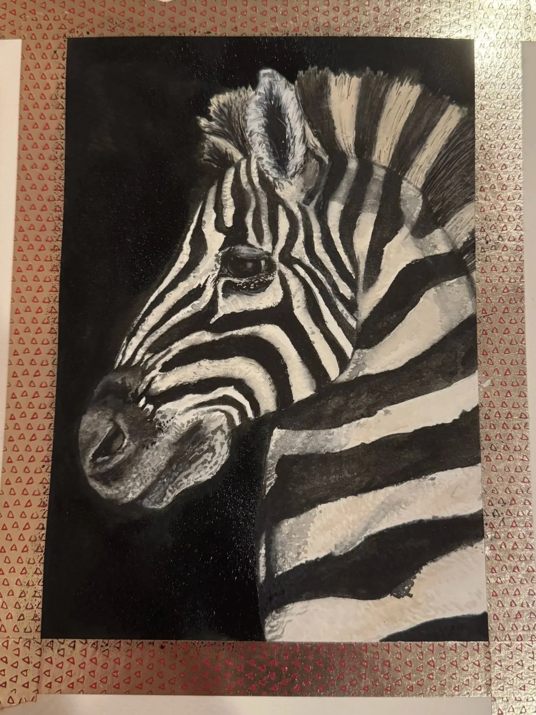 Black and white drawing of a zebra's head and neck, showing detailed stripes and facial features, on a dark background with a patterned border.