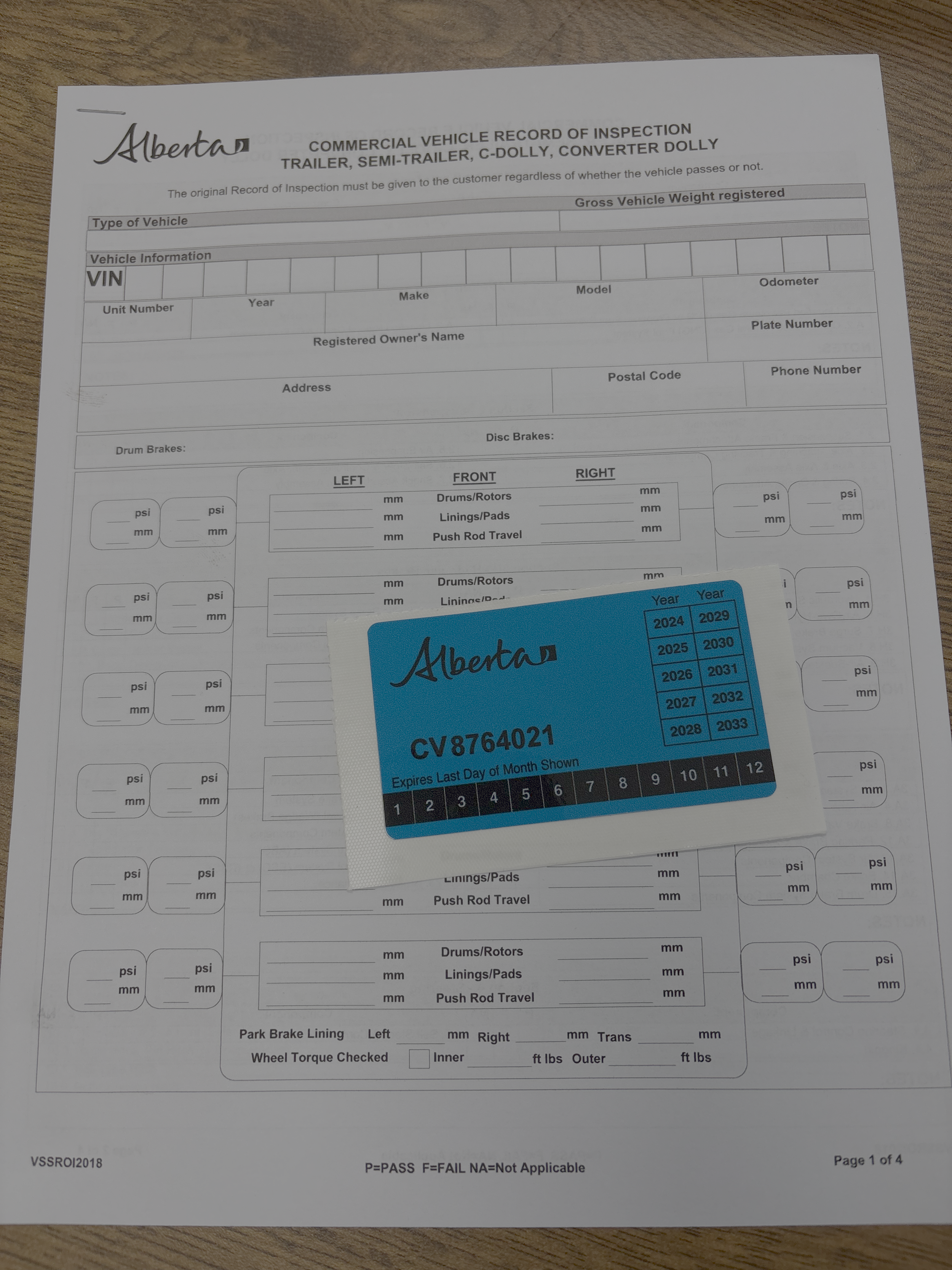 A commercial vehicle inspection form from Alberta with a blue sticker overlapping the lower right corner.