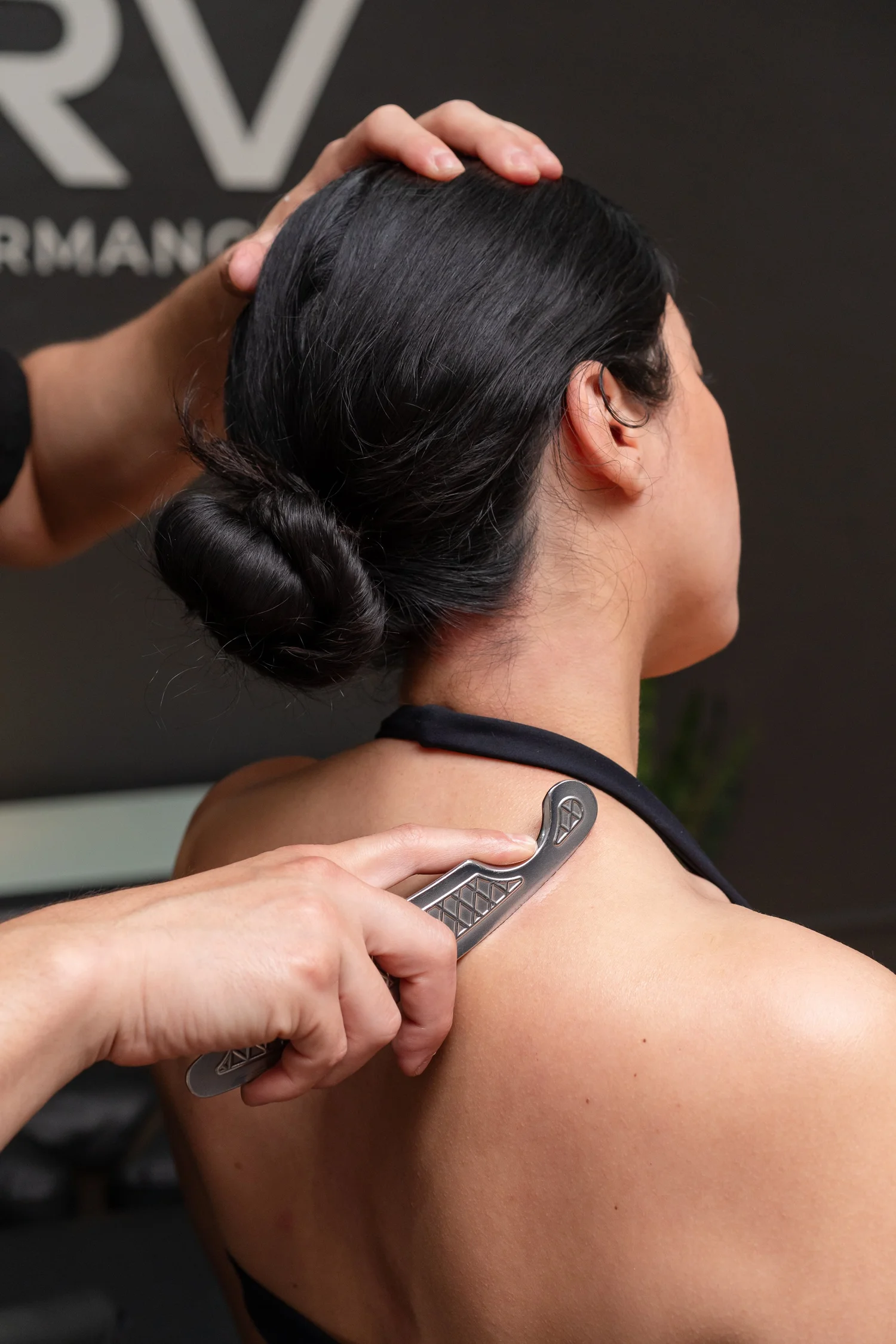 Instrument-assisted soft tissue work on the upper trapezius at NERV Chiropractic in Los Angeles