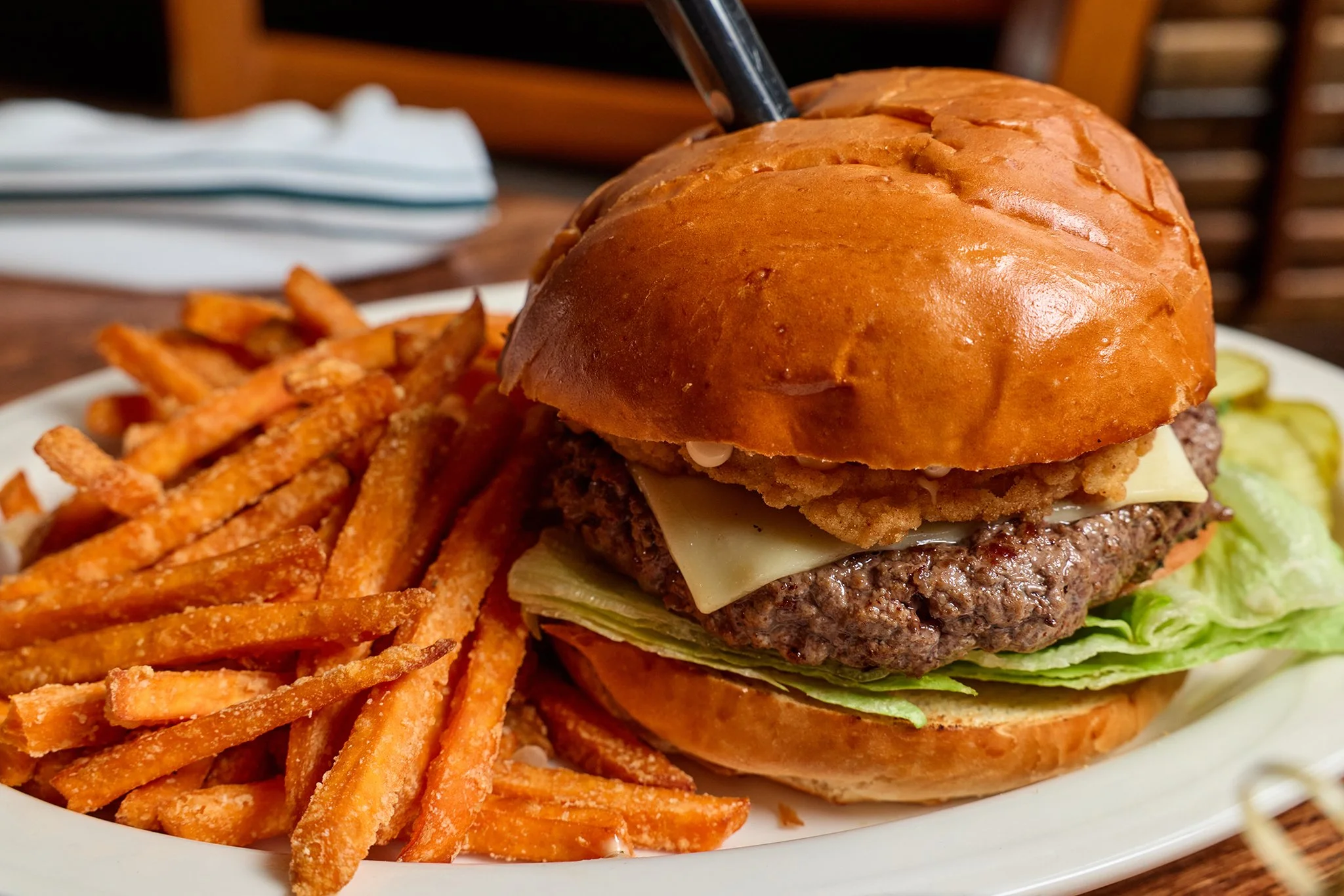 Plate with a cheeseburger and sweet potato fries