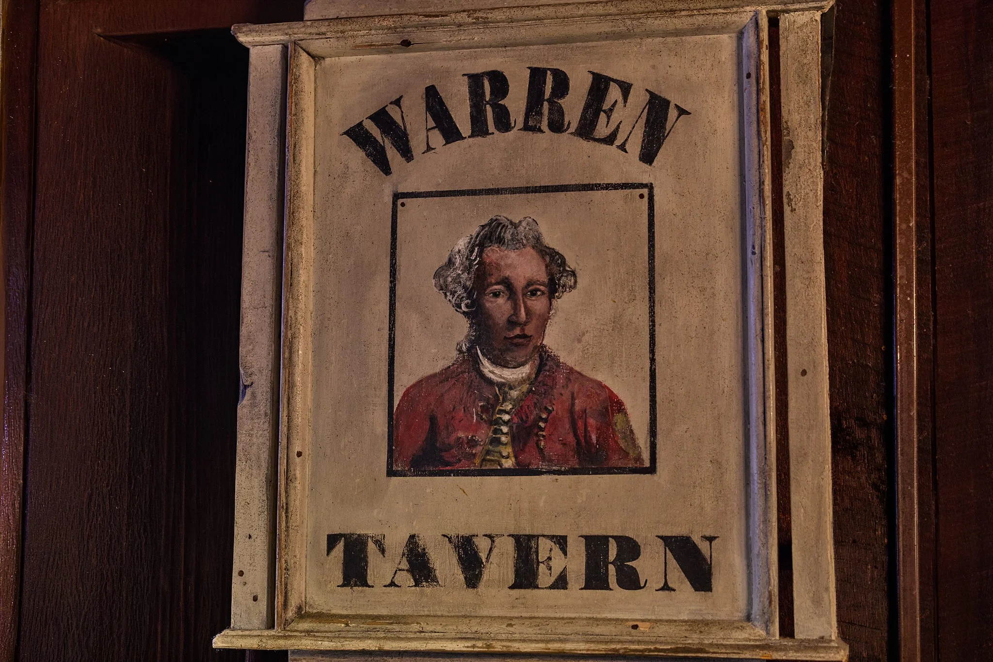 Poster with the word 'WARRIOR' at the top, featuring a portrait of a person in historical attire, and the word 'TAVERN' at the bottom.