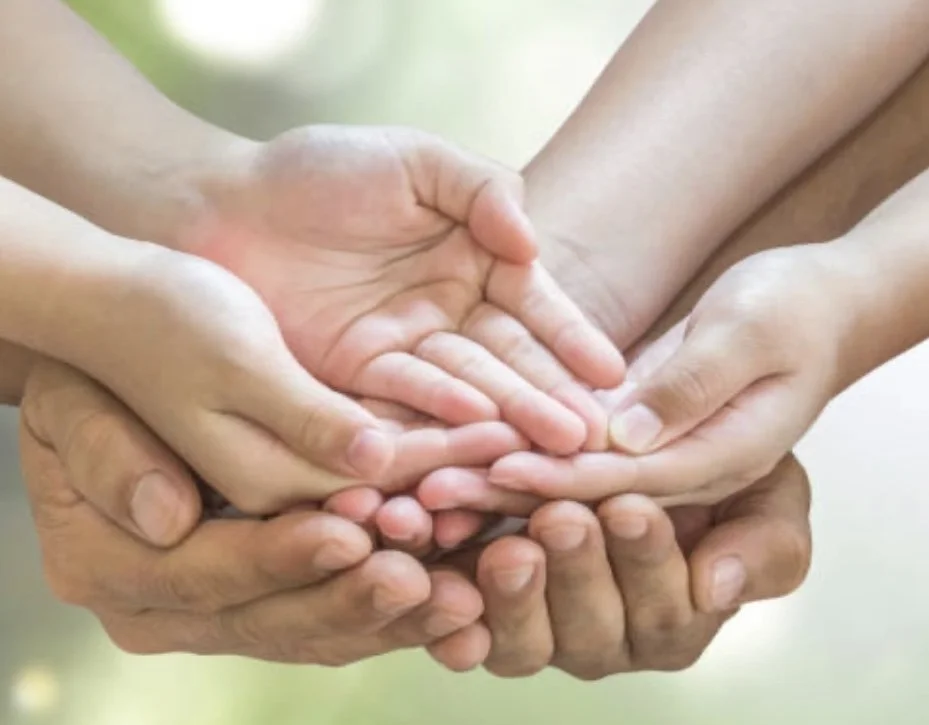 Multiple hands of different ages interconnected, symbolising unity and support for those experiencing loss and trauma. Gabrielle D Coaching in Amersham supports you with emotional transition training and Grief and Loss Coaching.