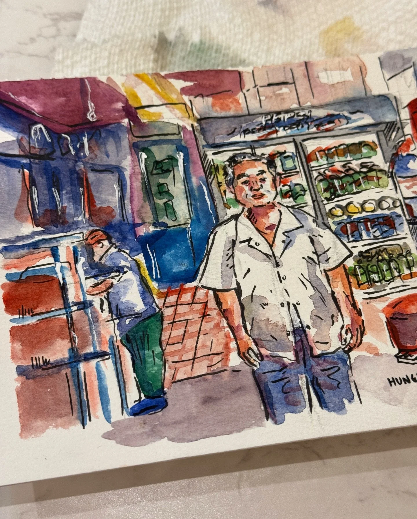 Watercolor sketch of a man standing outside a grocery store with shelves of produce behind him, another person sitting on a bench nearby.