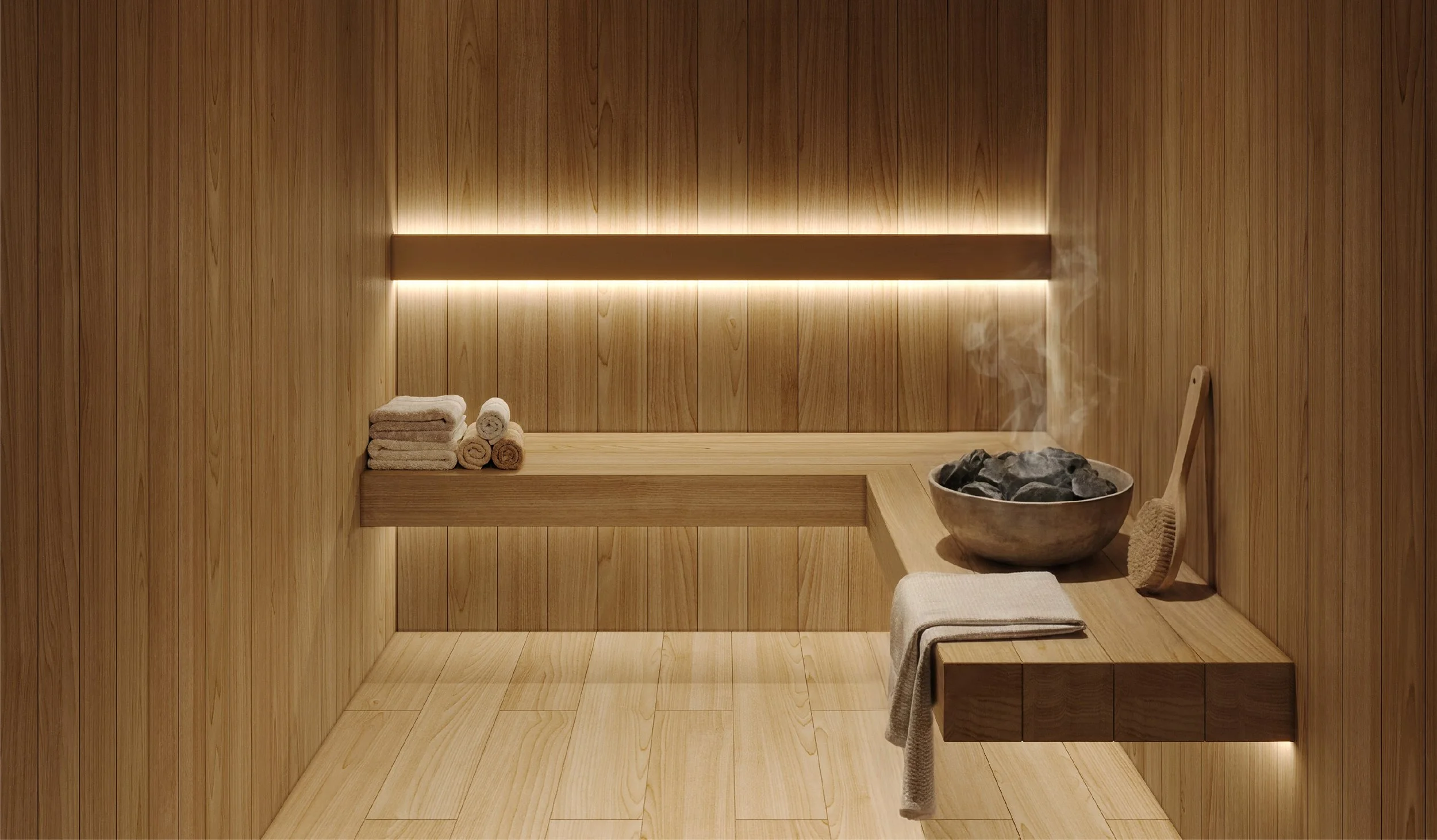 A sauna with wooden walls and bench, rolled towels, a bowl of stones, and a wooden whisk.