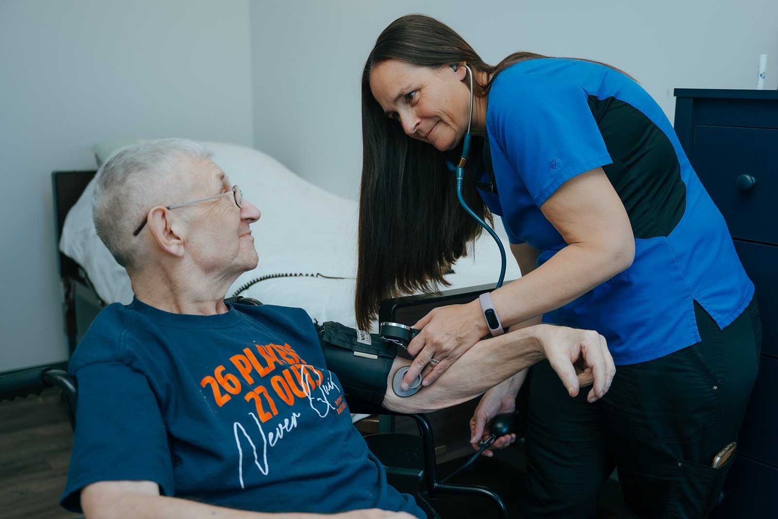 A nurse examines an elderly man using a blood pressure cuff in Avielle Haven where they offer long-term residential care, specialized memory care, and assisted living in Midland, Michigan.